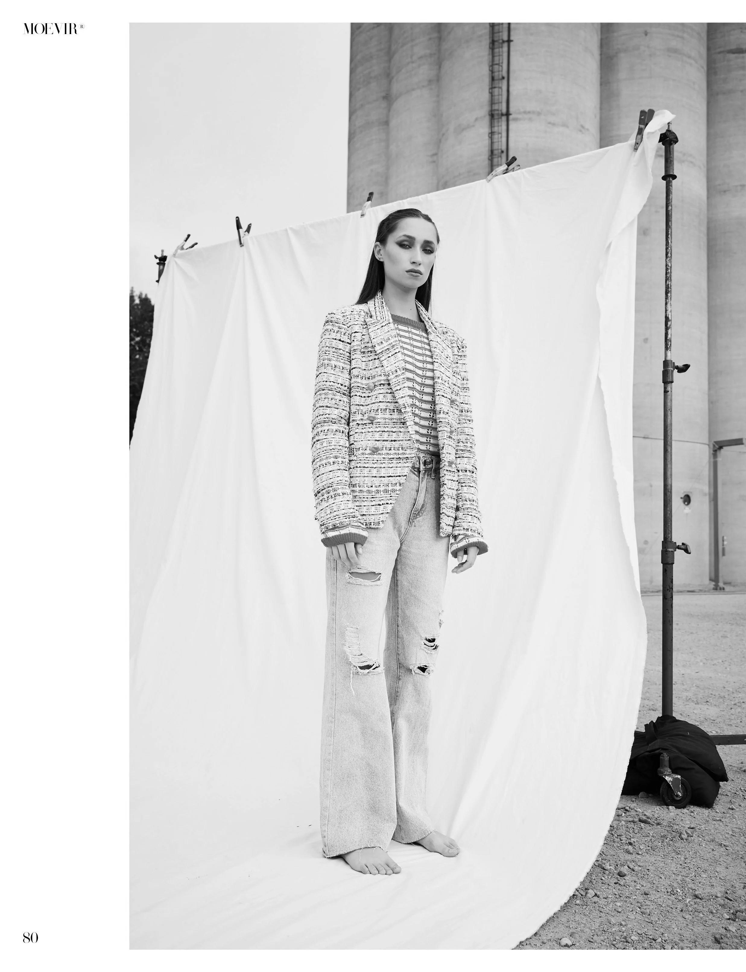  win Cities fashion styling featuring black and white image of model in jeans and tweed jacket in front of outdoor backdrop 