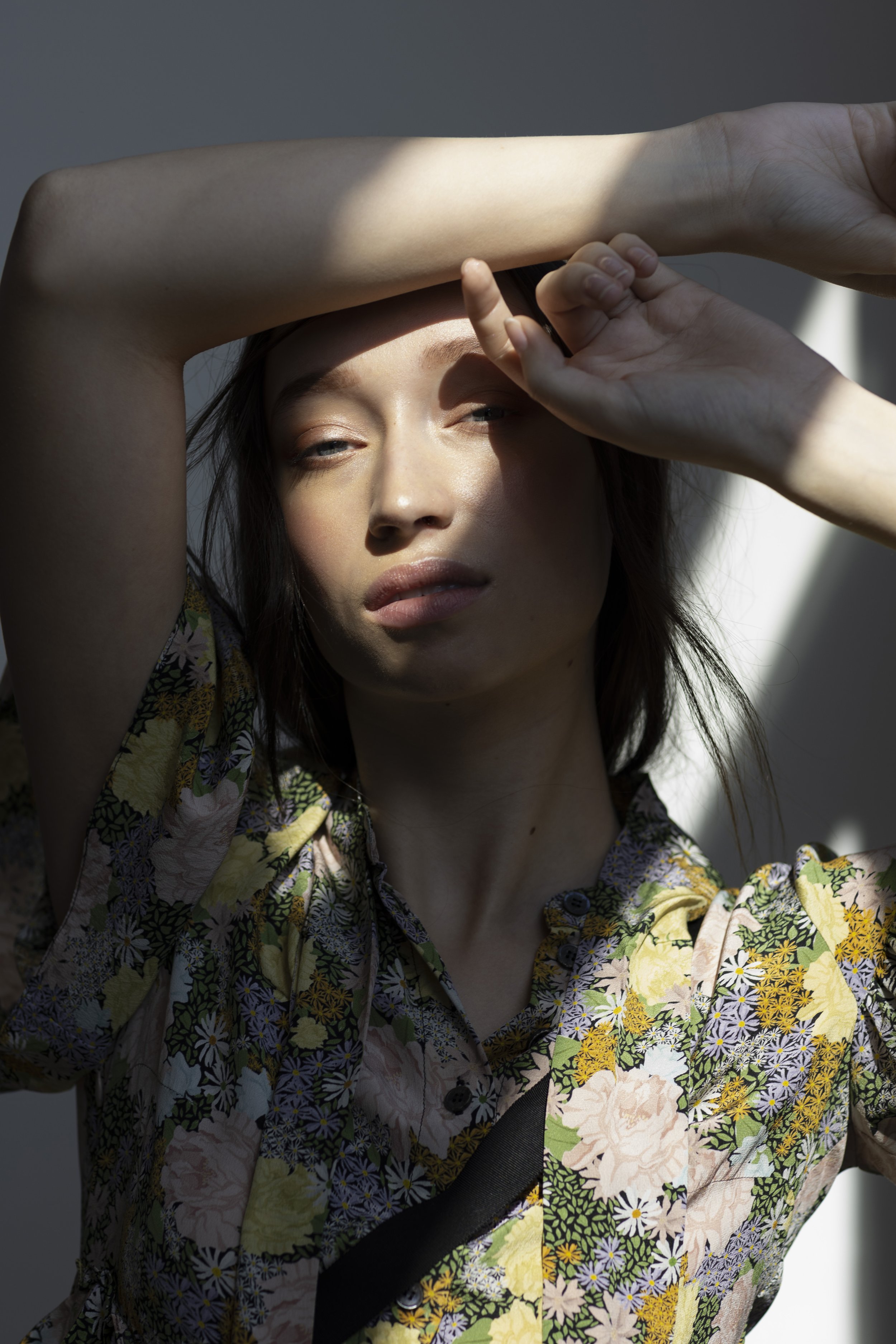  St. Paul fashion styling featuring close-up of model’s face in shadow with floral top and moody aesthetic 