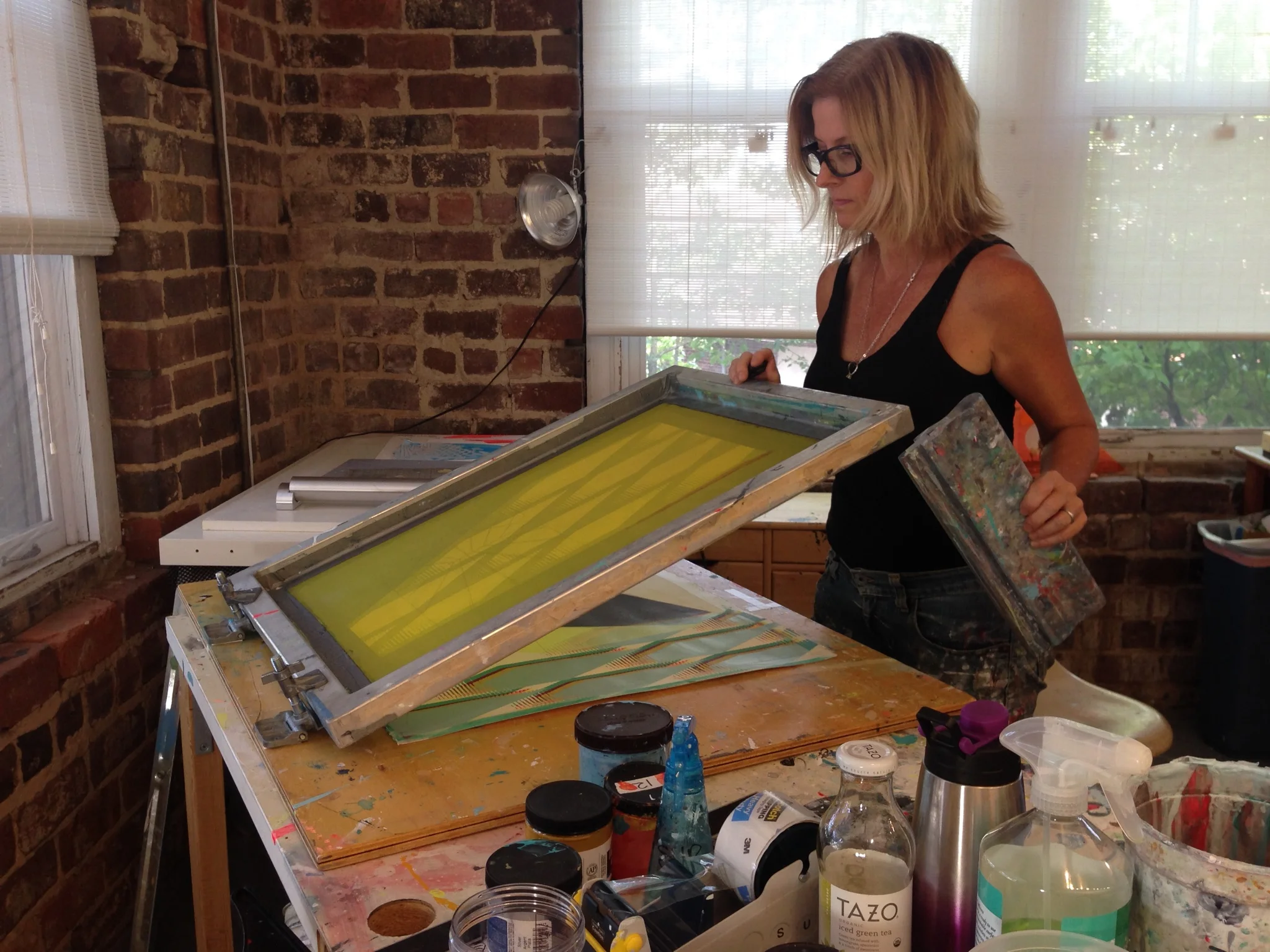 Stacie works with screenprinting equipment in her studio.
