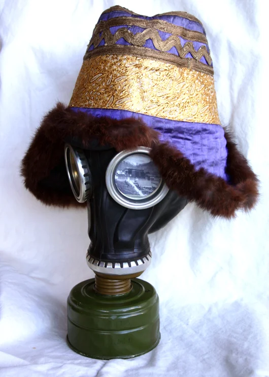 1959, gas mask, Tibetan woman's hat, and photographs, 14.5" x 12" x 11"