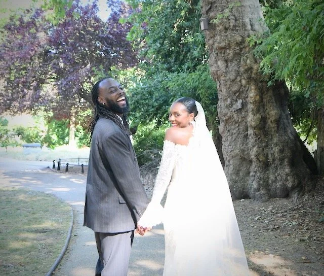 Newly married couple sharing a joyful laughter in the park, photographed by a London wedding photographer specialising in natural and relaxed wedding photography.