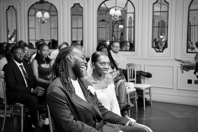 Bride and groom laughing during their London wedding ceremony surrounded by family and friends