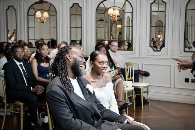 Bride and groom laughing during their London wedding ceremony surrounded by family and friends