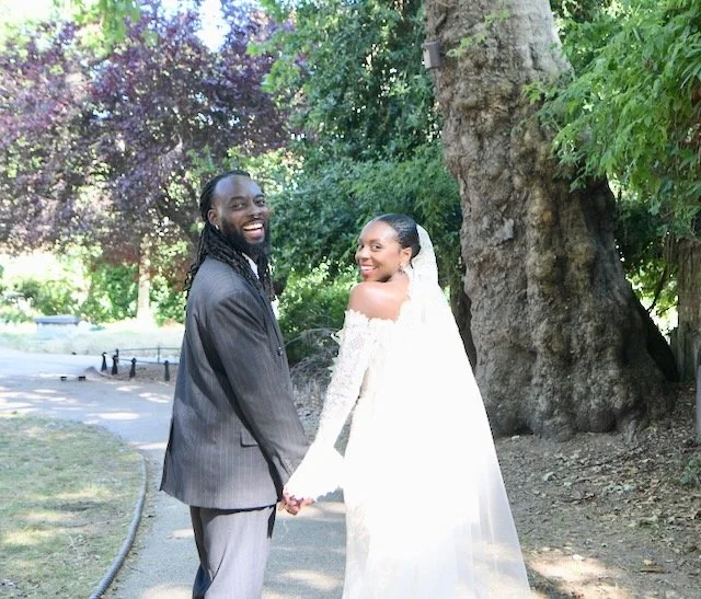 Newly married couple sharing a joyful laughter in the park, photographed by a London wedding photographer specialising in natural and relaxed wedding photography.