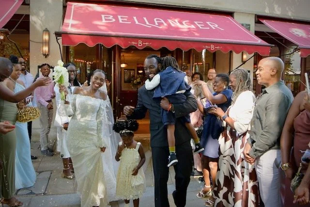 Bride and groom celebrating their confetti exit outside a London wedding venue with family and guests.