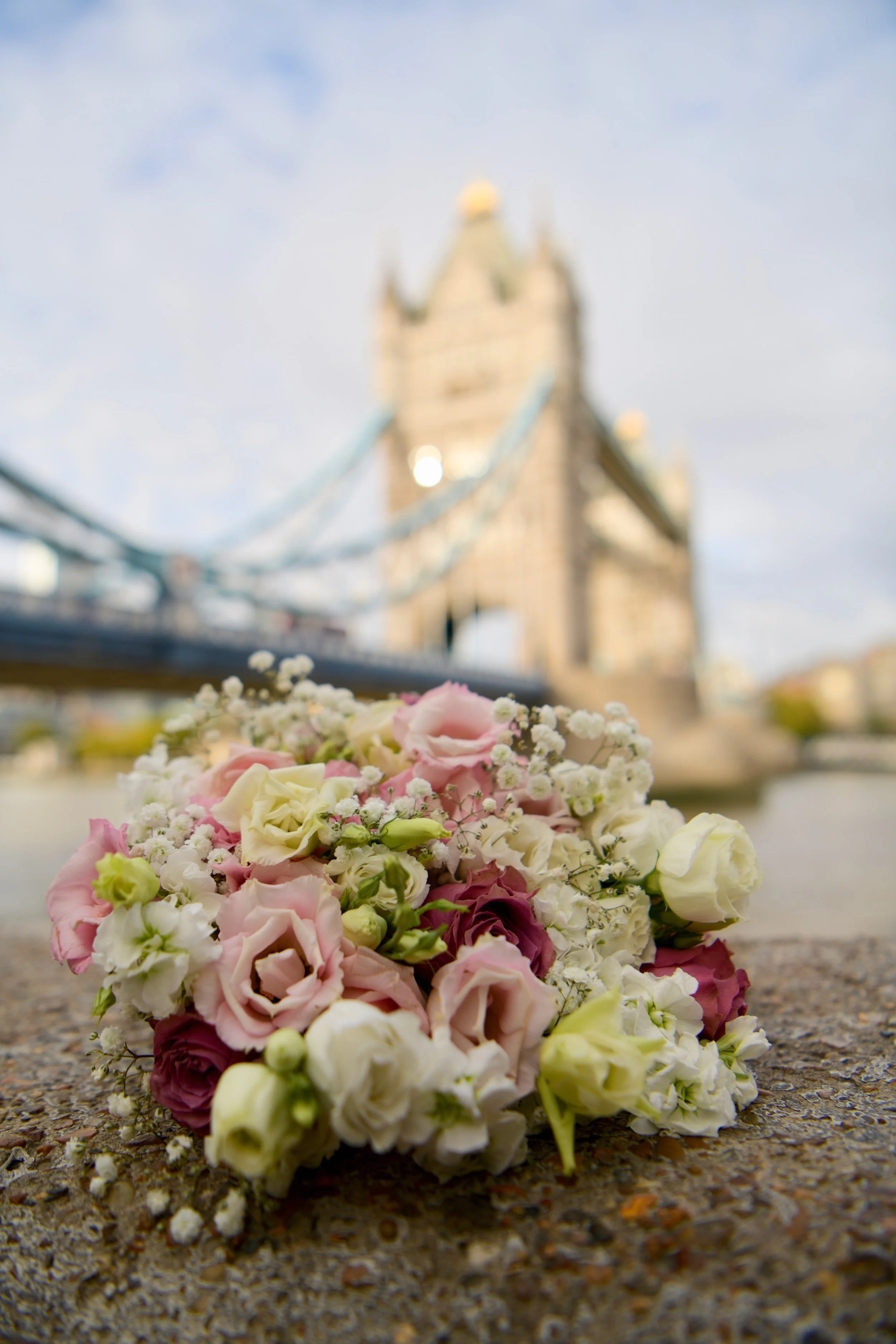 Wedding bouquet with pale roses in front of Tower Bridge, London