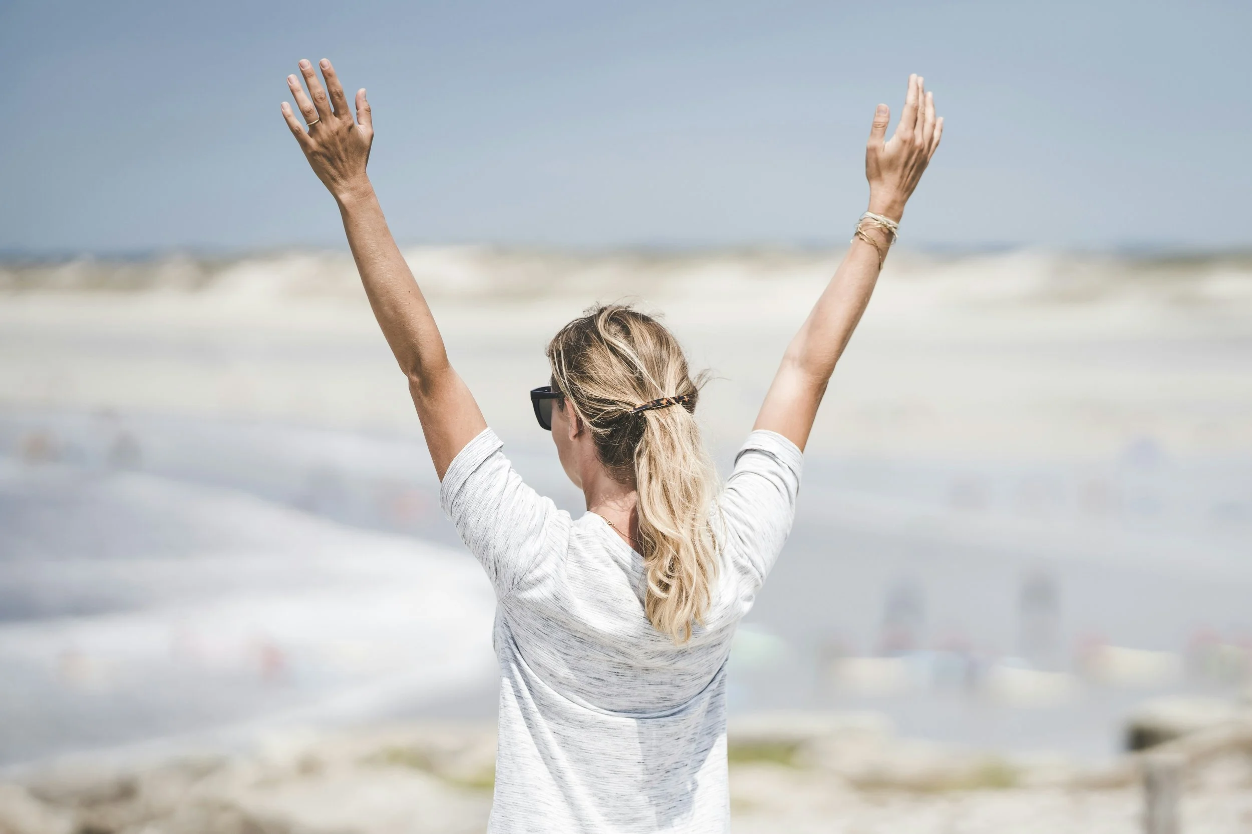 Woman standing in sunlight with open posture reflecting emotional relief after burnout and over-functioning