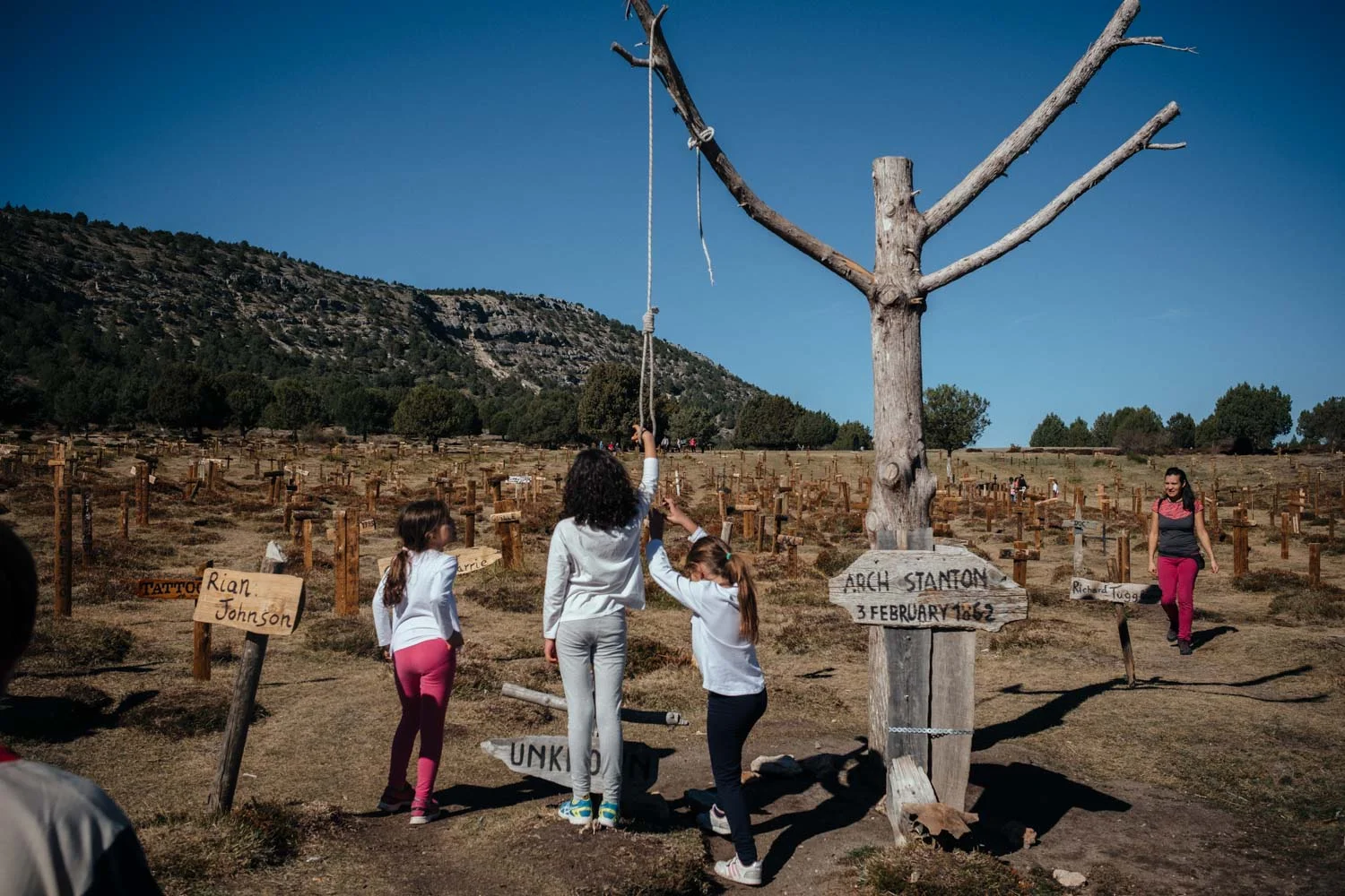 They hang themselves from the noose hovering above the grave marked "UNKNOWN".