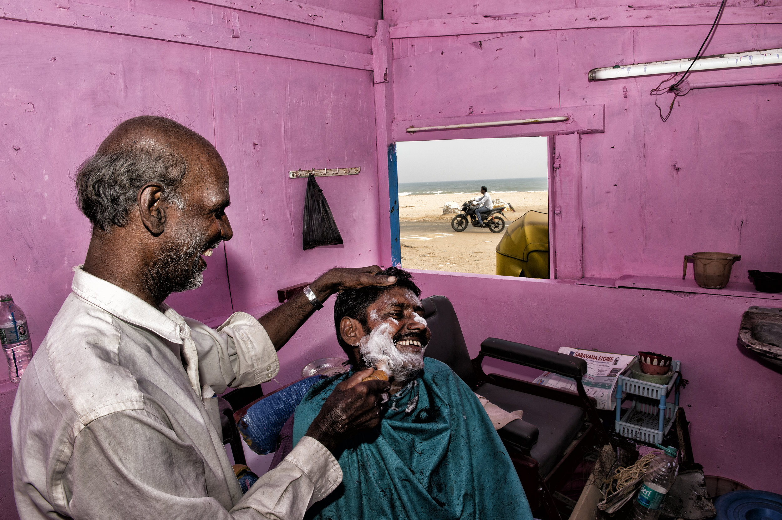 Hairdresser on the beach in India for National Geographic