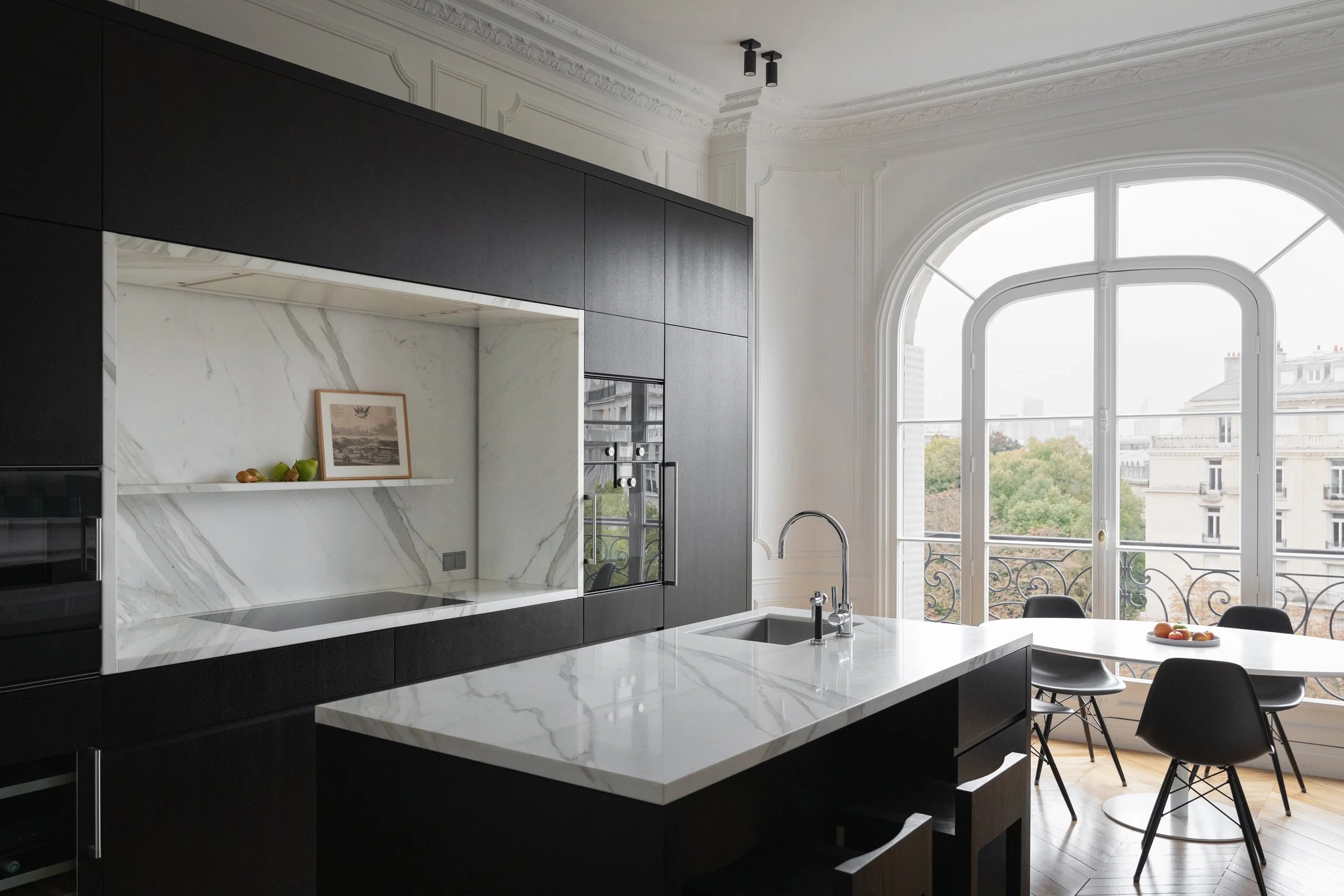 Cuisine Obumex sur mesure en bois sombre et pierre blanche dans un appartement haussmannien à Paris 16