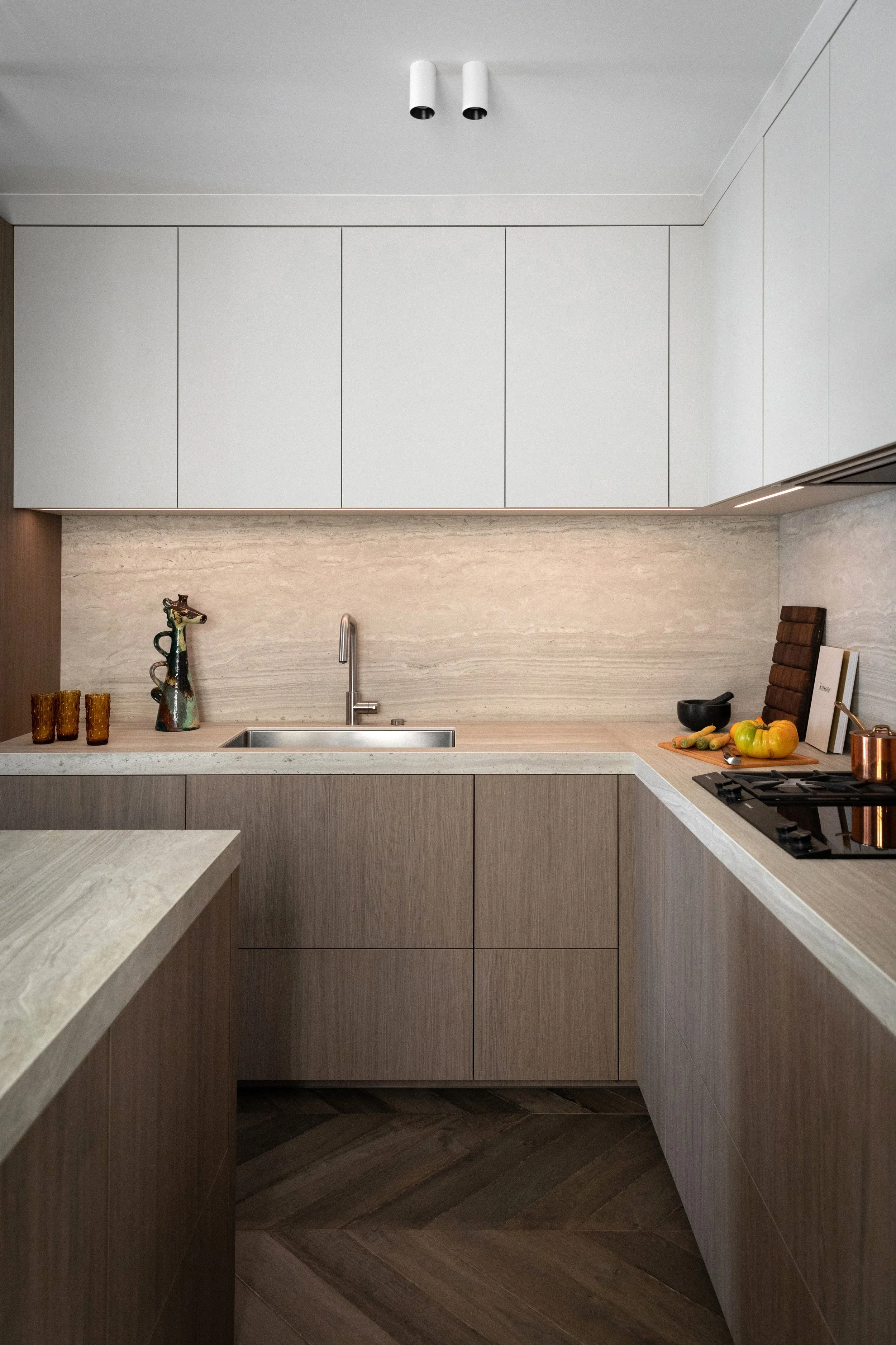 Détail de la cuisine et son îlot en bois avec plan de travail en céramique effet pierre dans un appartement rénové à Paris 3
