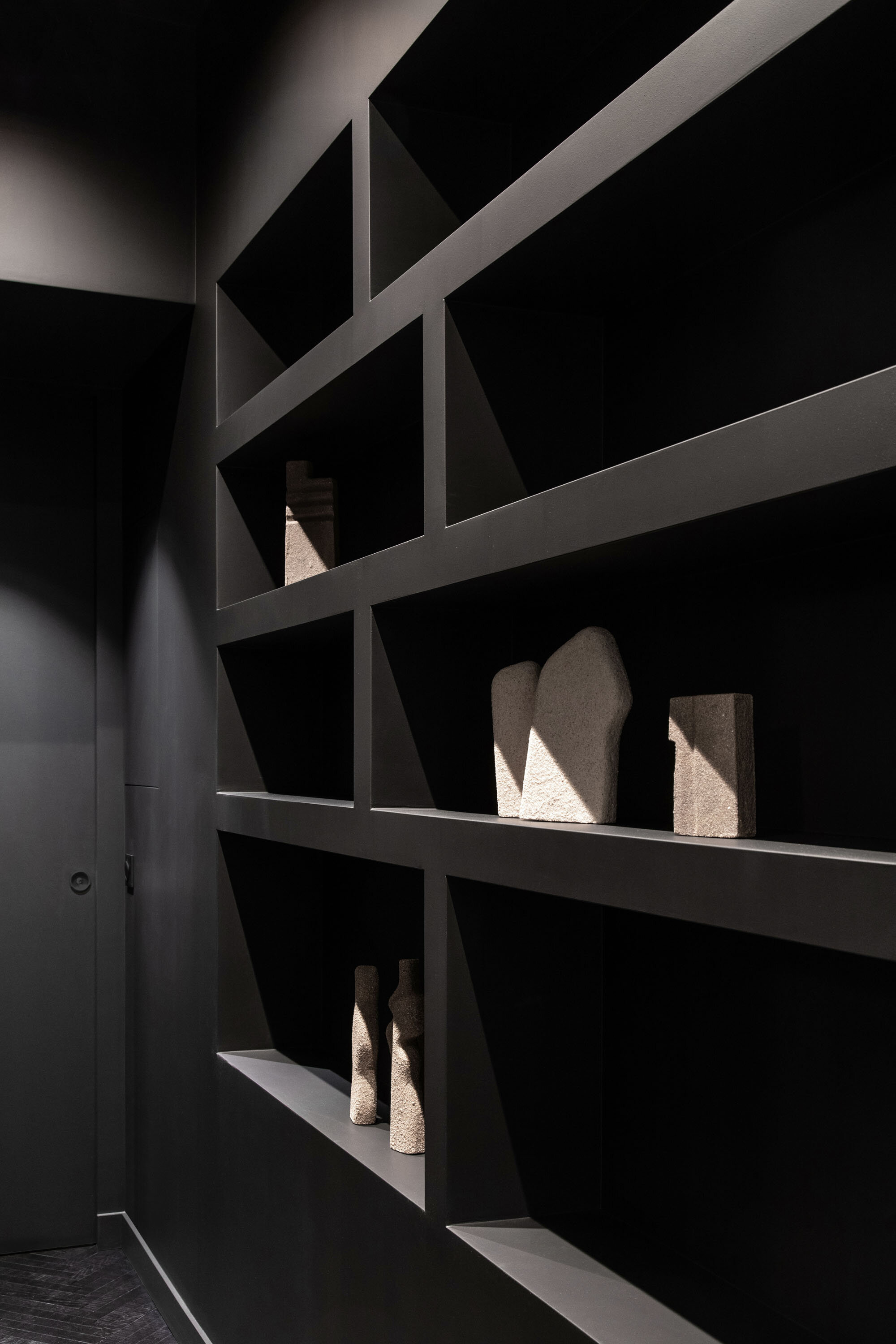 Détail d’une bibliothèque noire sur mesure dans un appartement parisien