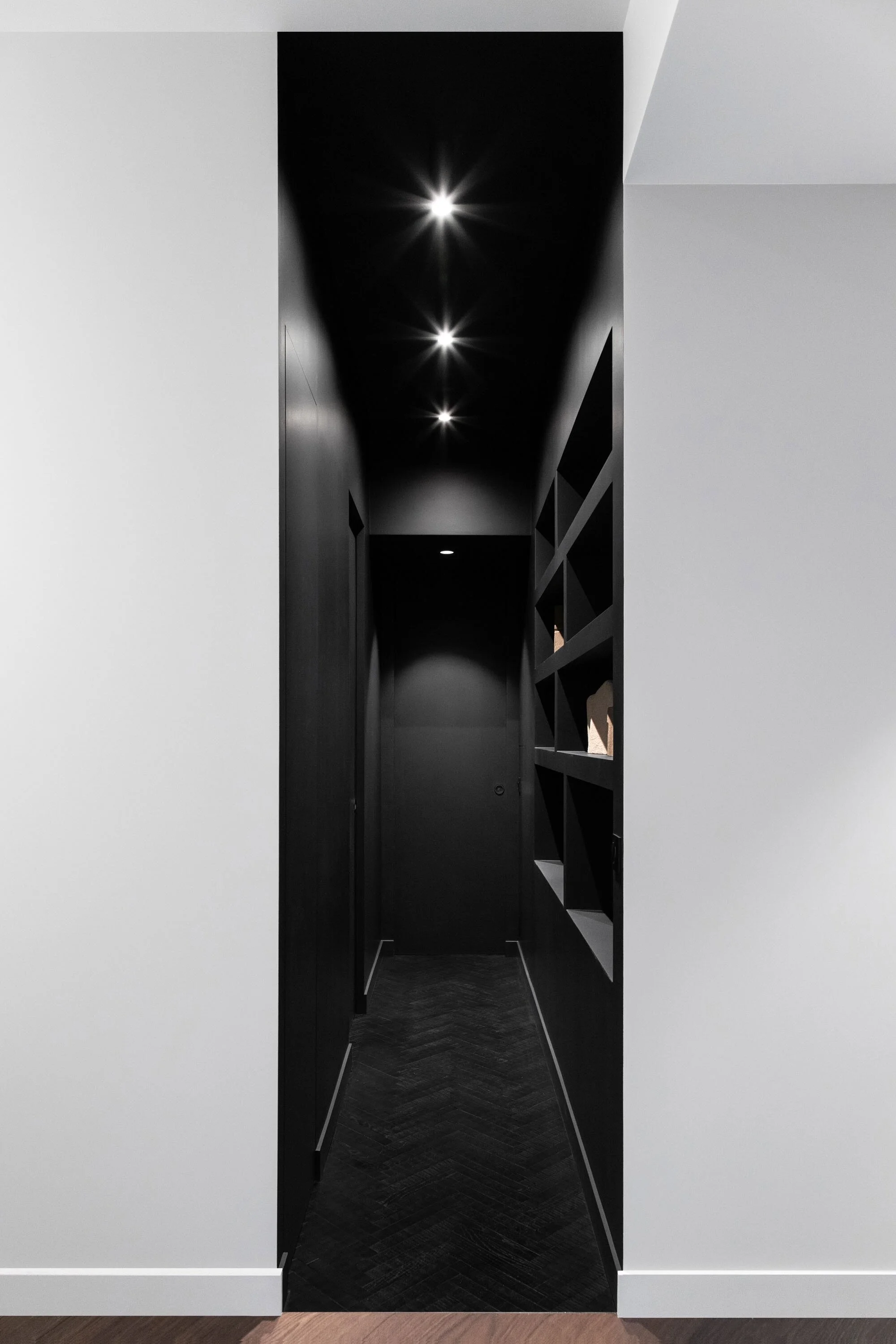 Couloir noir avec rangements sur mesure dans un appartement parisien