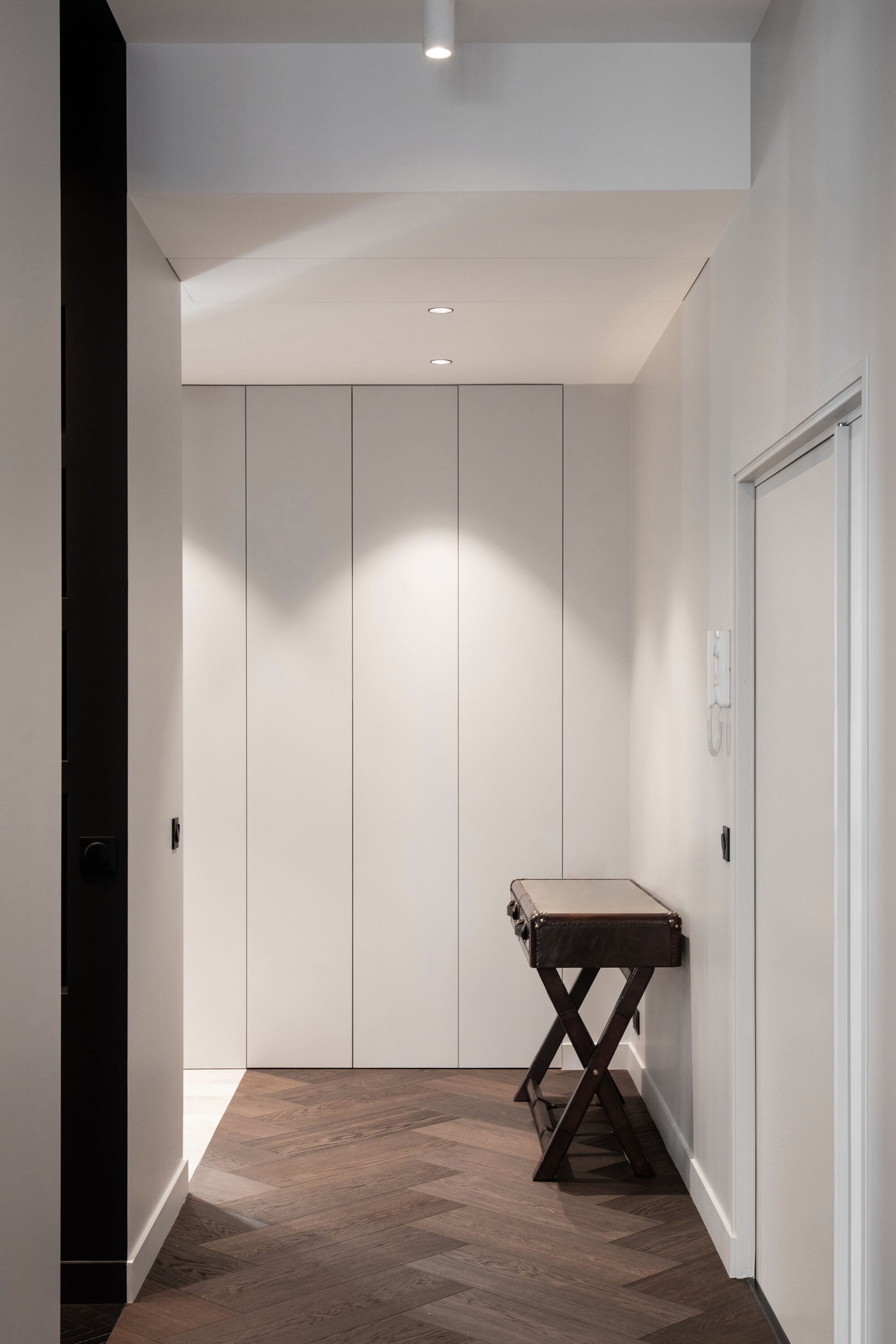 Entrée avec rangements sur mesure et parquet bauwerk d'un appartement parisien