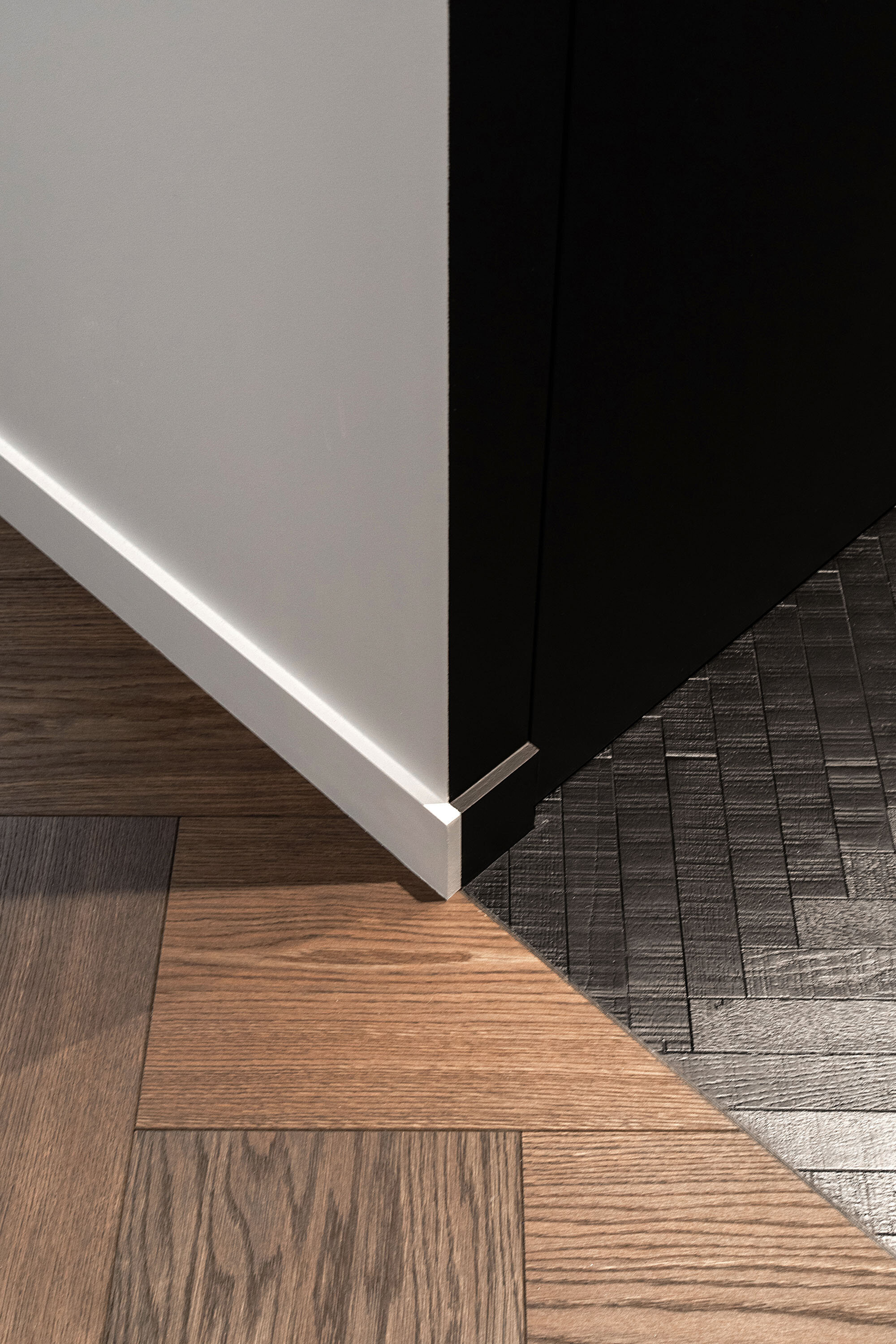Détail de la jonction et du calepinage entre parquet bois et sol noir