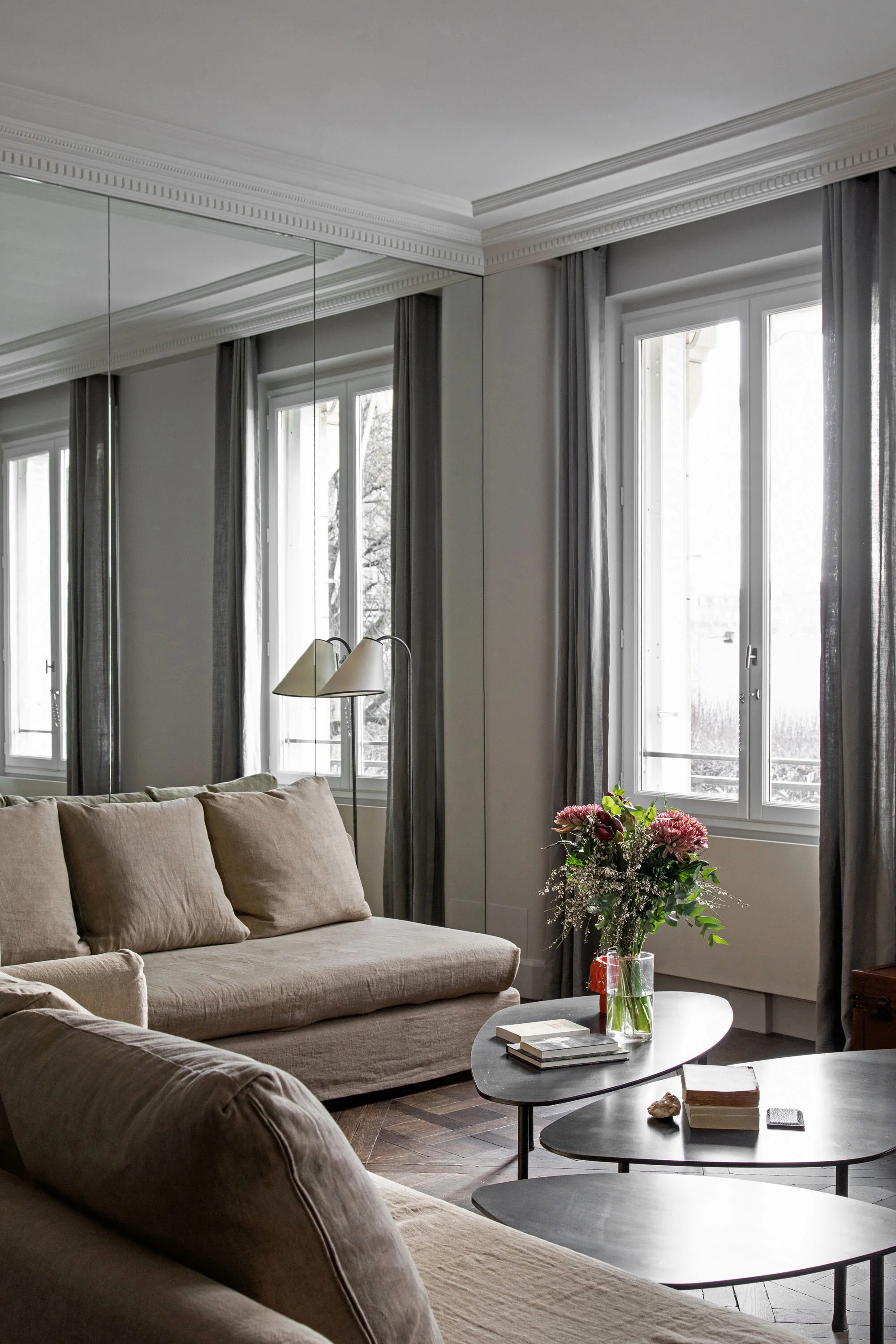 Salon avec murs miroirs et moulures dans un appartement parisien sur l'ile de la cité