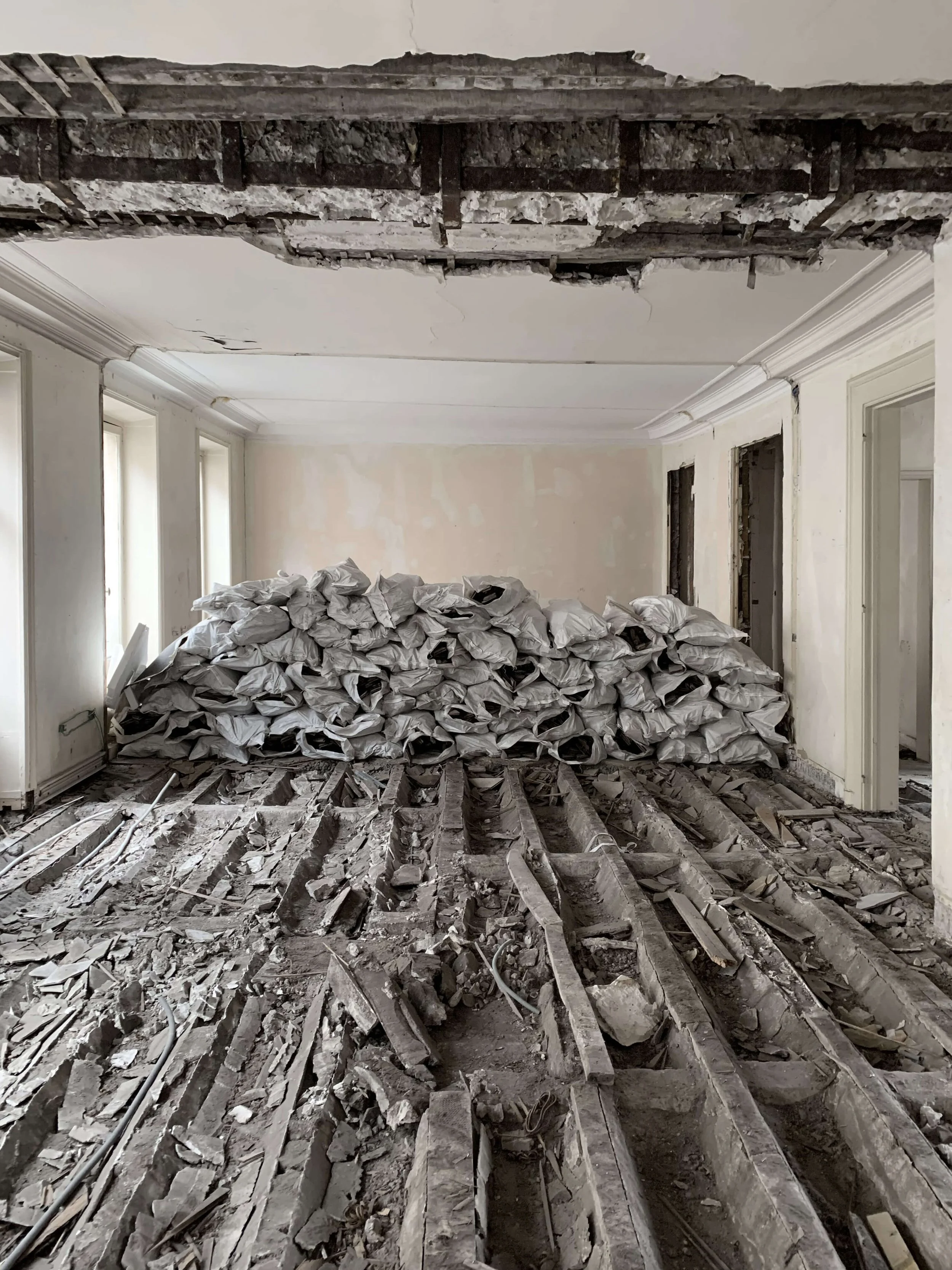 Les sacs de gravats de la démolition d'un plancher bois dans un immeuble haussmannien