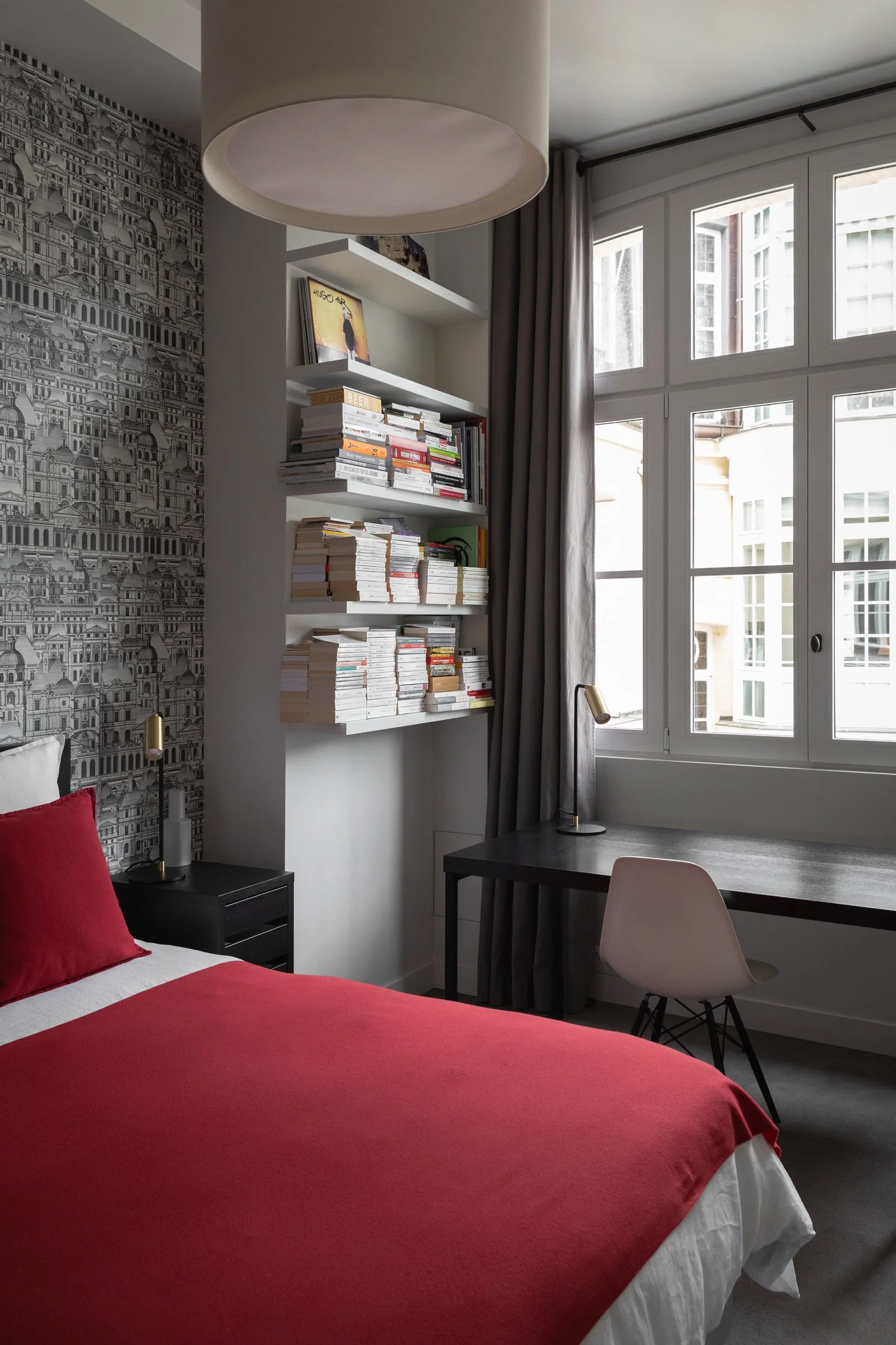 Chambre avec bibliothèque sur mesure, bureau intégré et papier peint graphique dans un appartement parisien