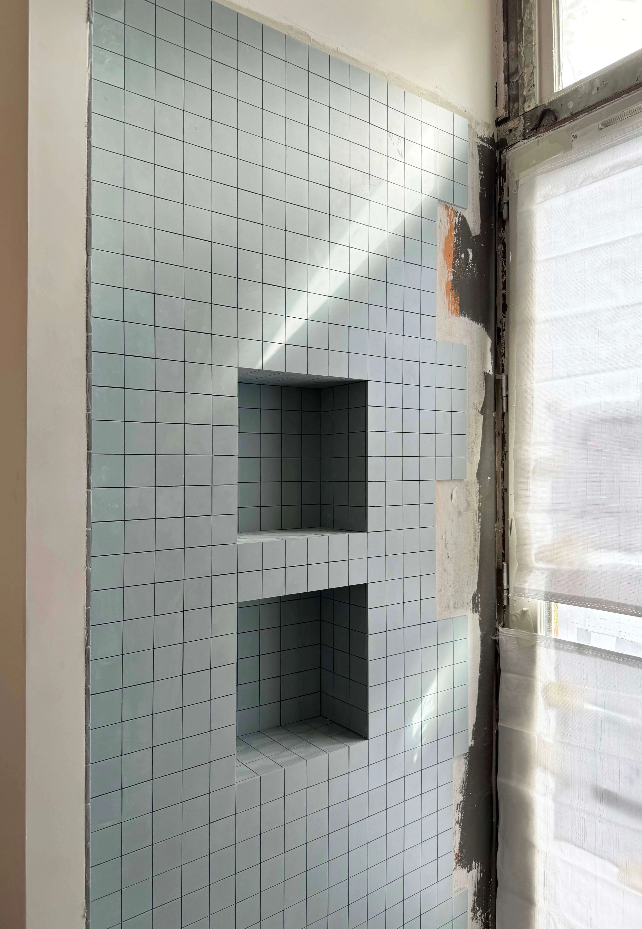 Détail des niches carrelées dans la douche d'un appartement à Paris 16