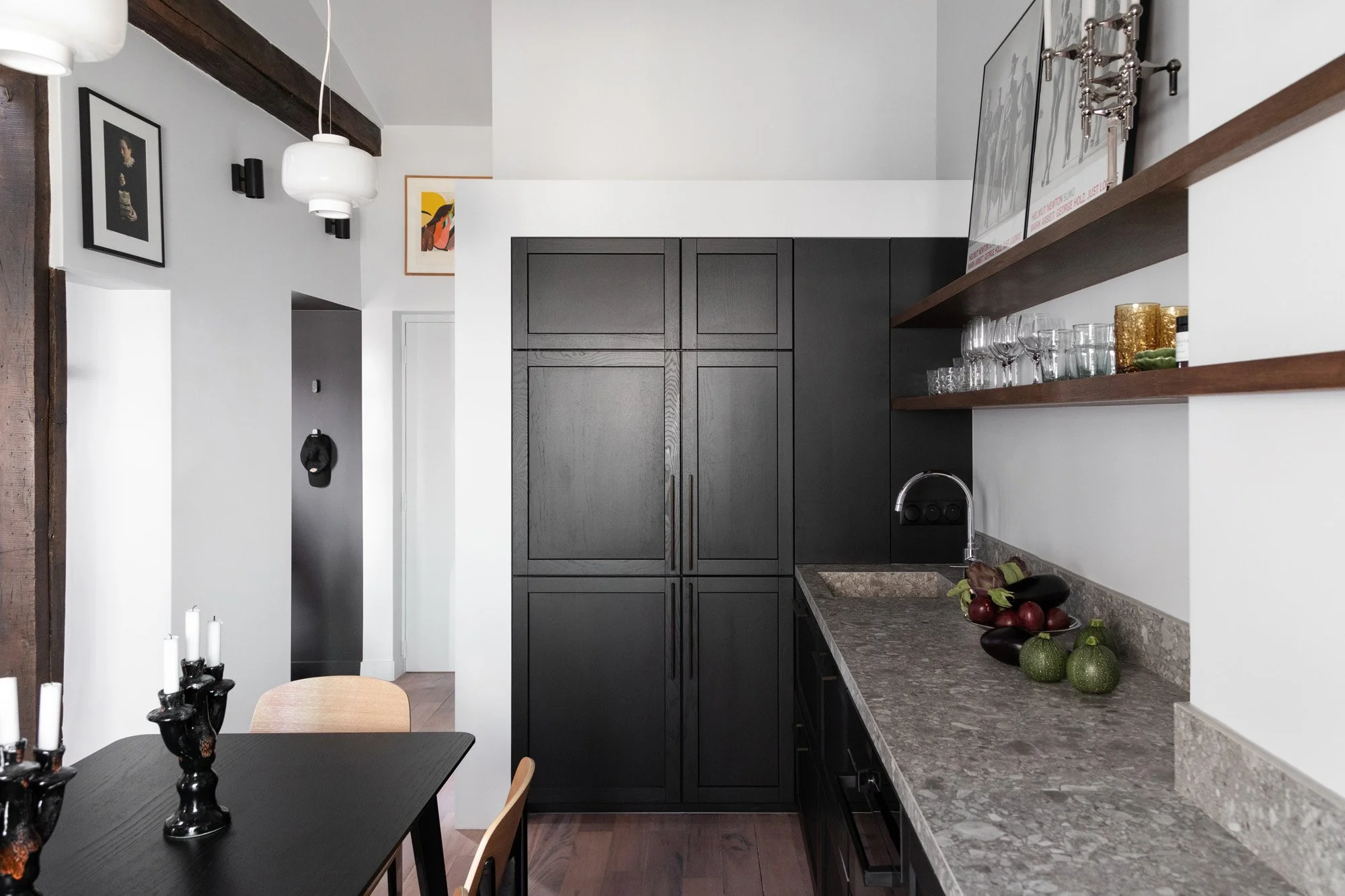 Cuisine noire avec plan de travail en pierre dans un appartement rénové à Paris 9