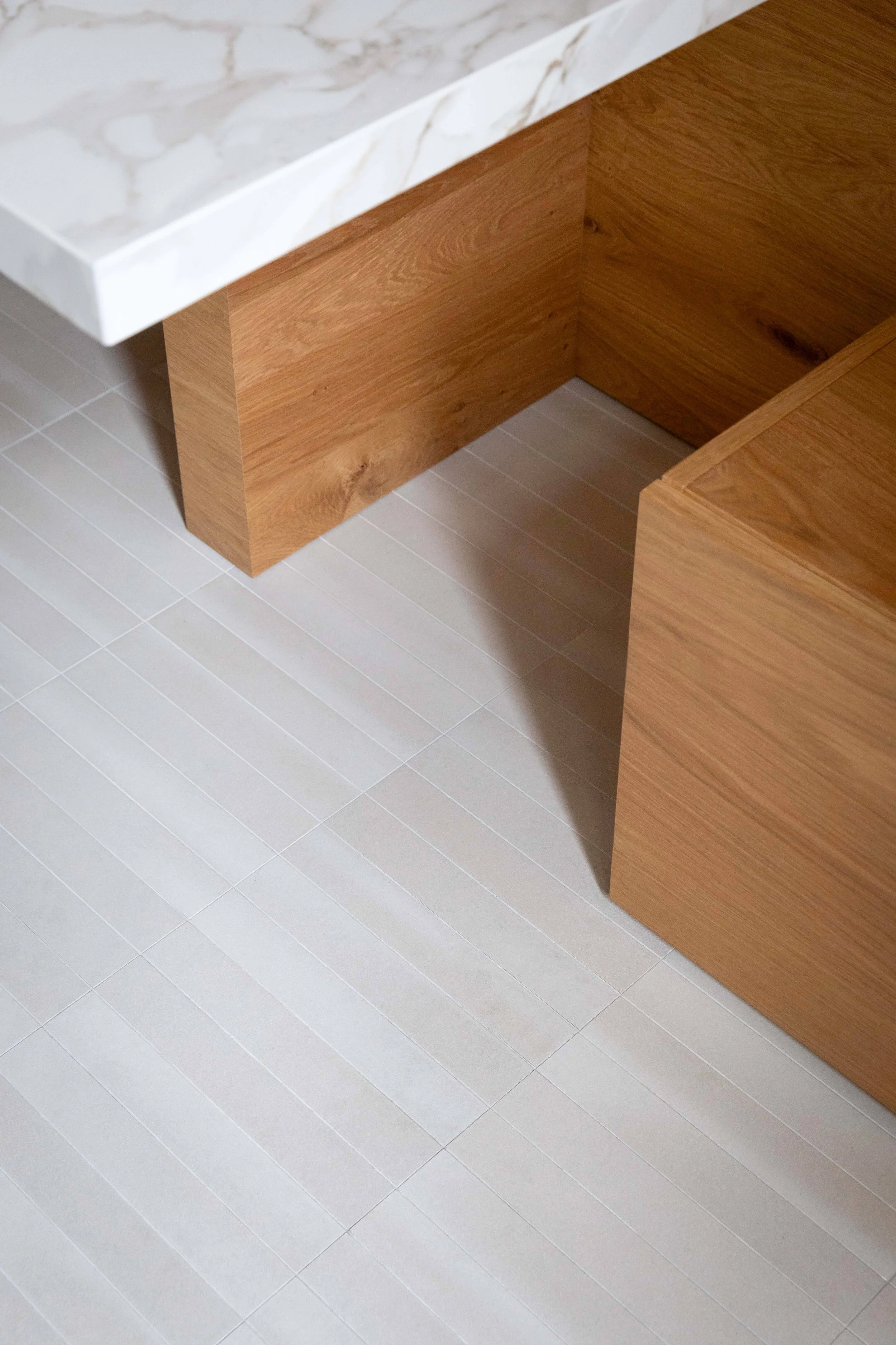 Mobilier en bois sur mesure et plan de travail en pierre dans la cuisine d’un appartement rénové à Paris 16