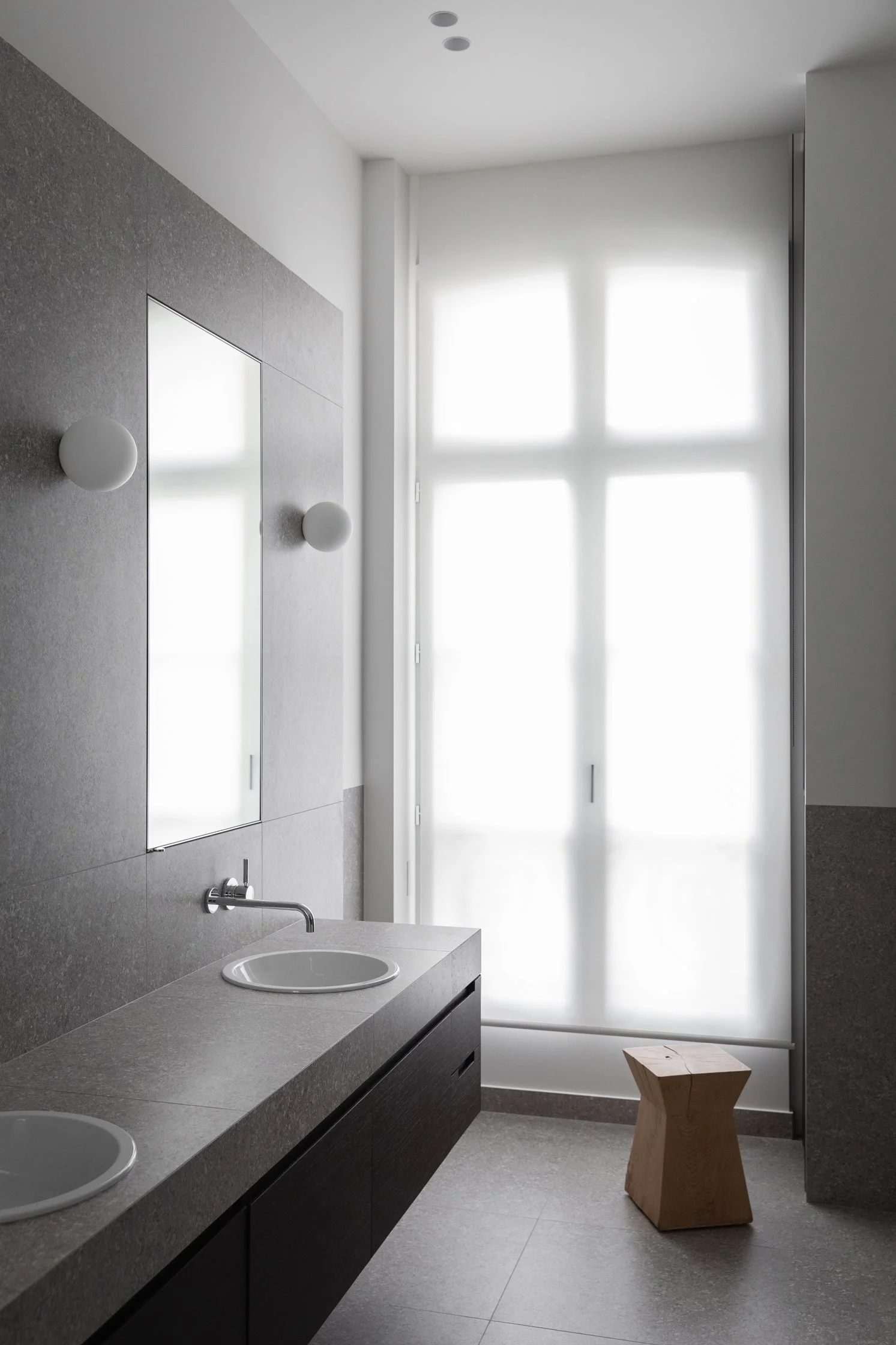 Salle de bain en gré cérame avec meuble double vasque et miroir dans un appartement rénové à Paris