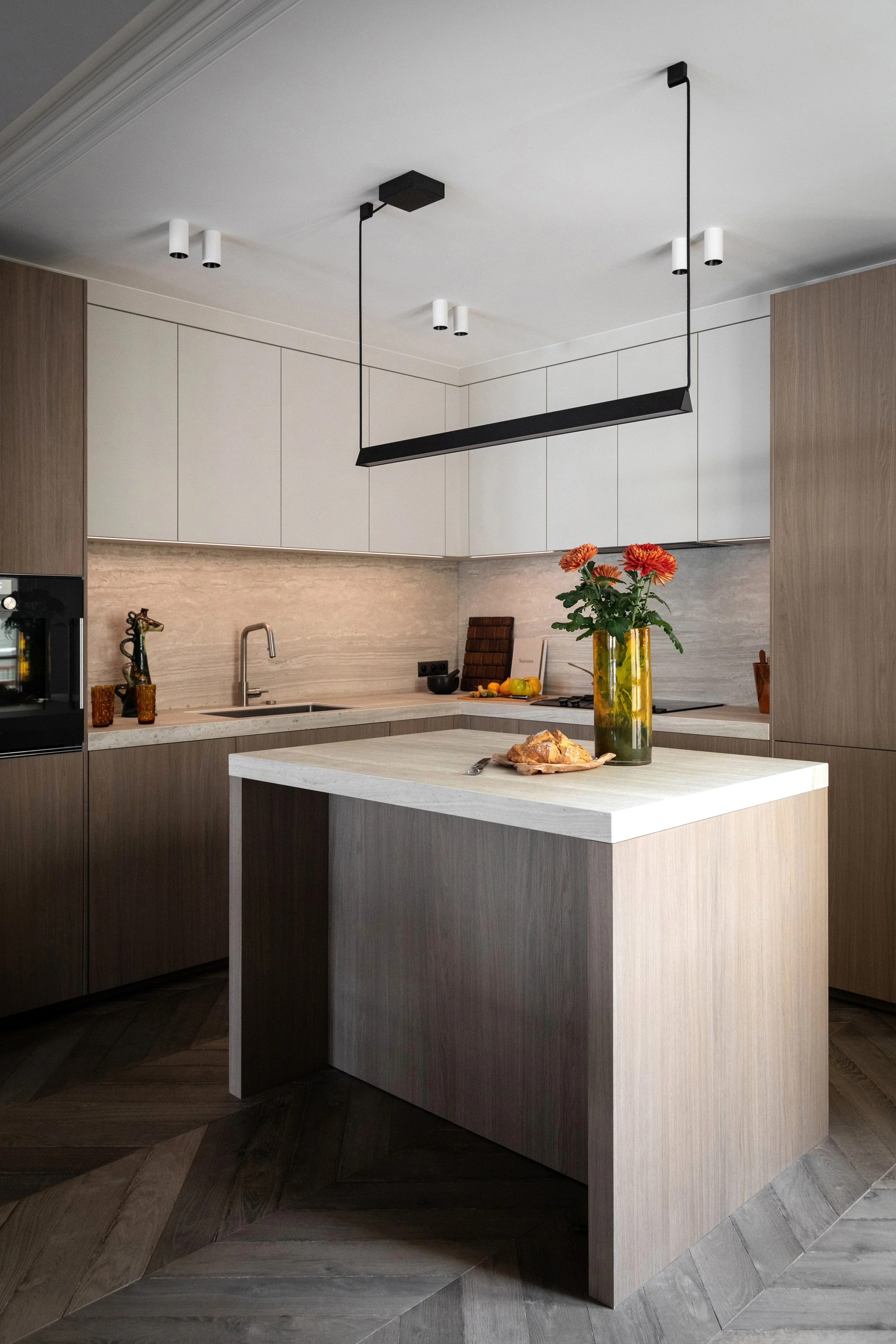 Cuisine ouverte sur la salle à manger et son îlot dans un appartement rénové du Marais à Paris 3