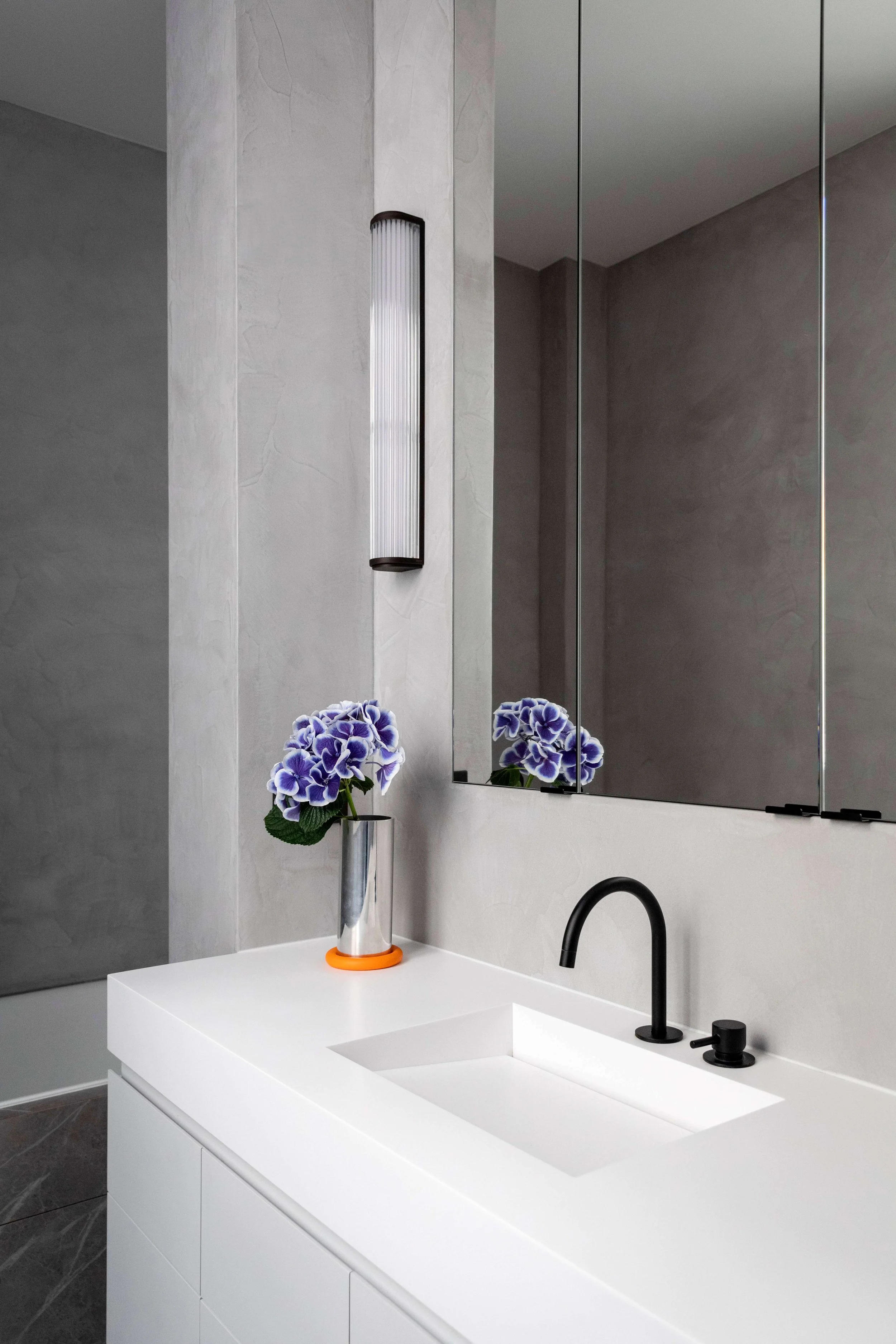 Vasque sur mesure et miroir dans une salle de bain contemporaine d’un appartement rénové à Paris 16