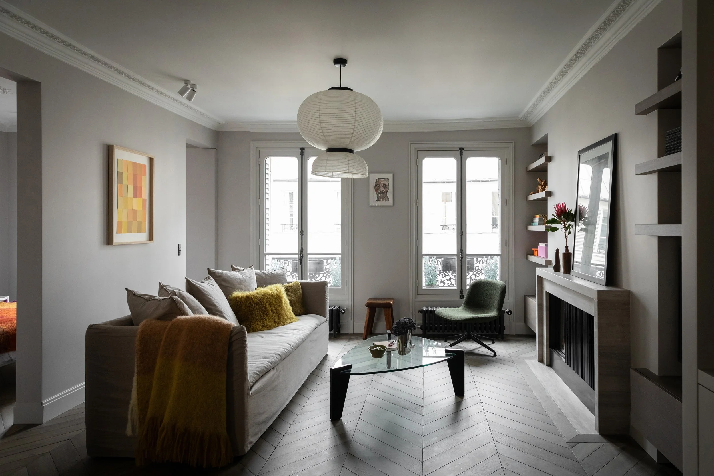 Salon d’un appartement rénové dans le Marais à Paris 3 avec cheminée et parquet en point de Hongrie