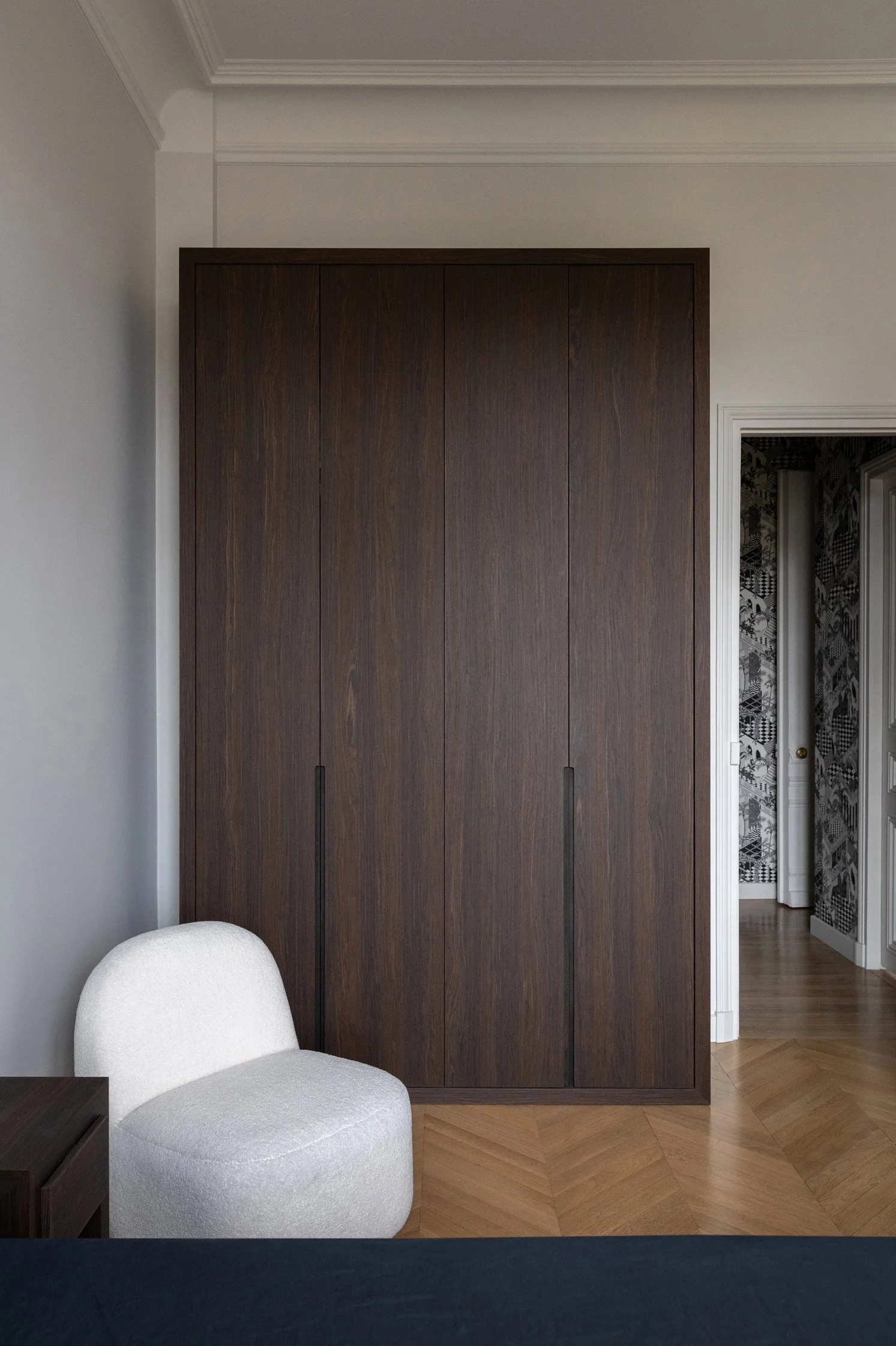 Dressing en bois sombre sur mesure dans une chambre d’un appartement haussmannien rénové