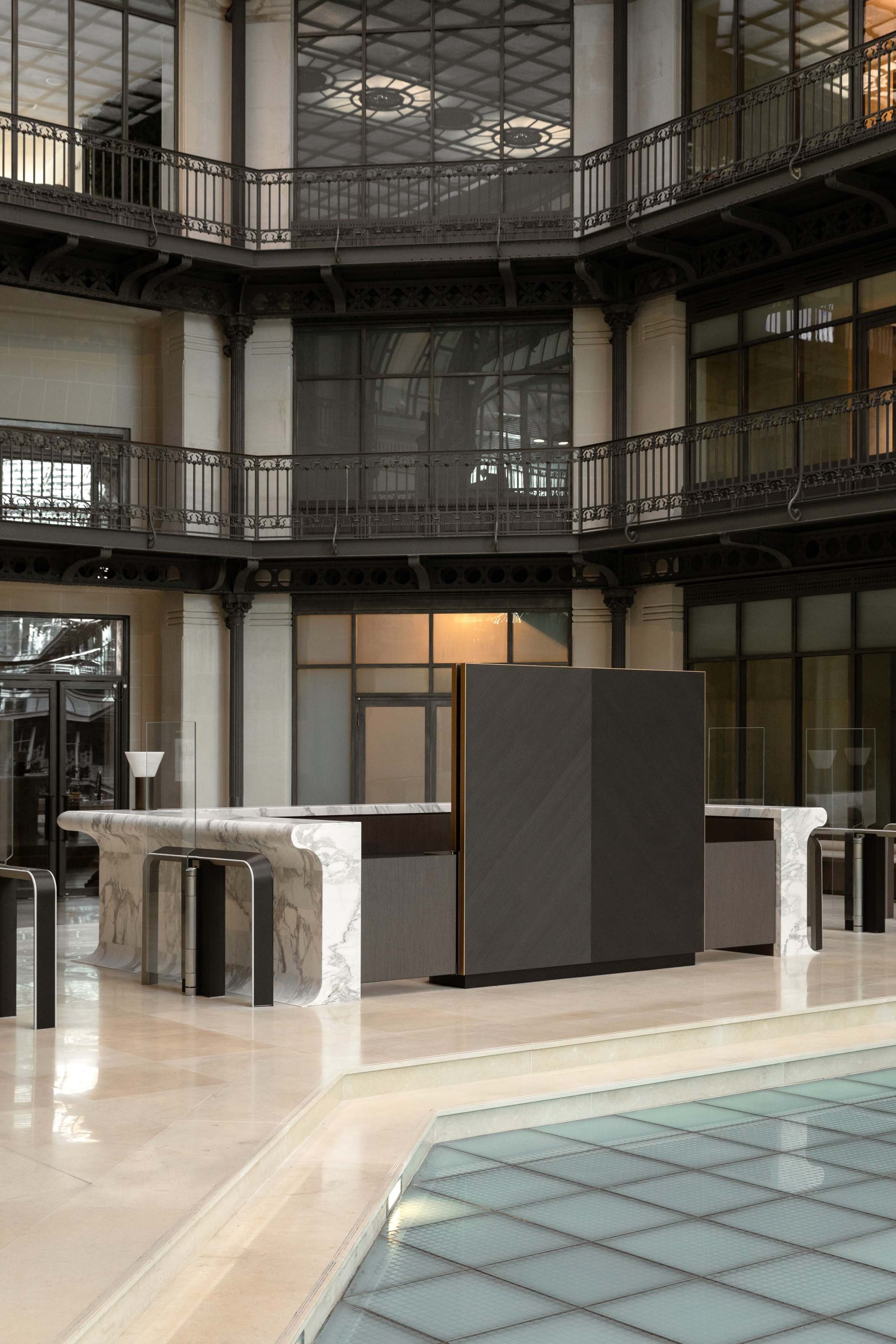 Banque d’accueil et paravent en bois noir dans le hall d’un immeuble tertiaire à Paris 2