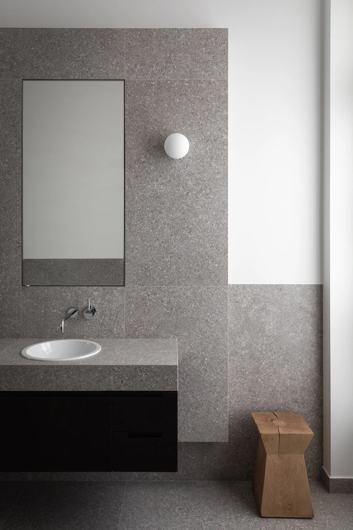 Salle de bain en gré cérame effet pierre grise avec miroir intégré et meuble vasque sur mesure