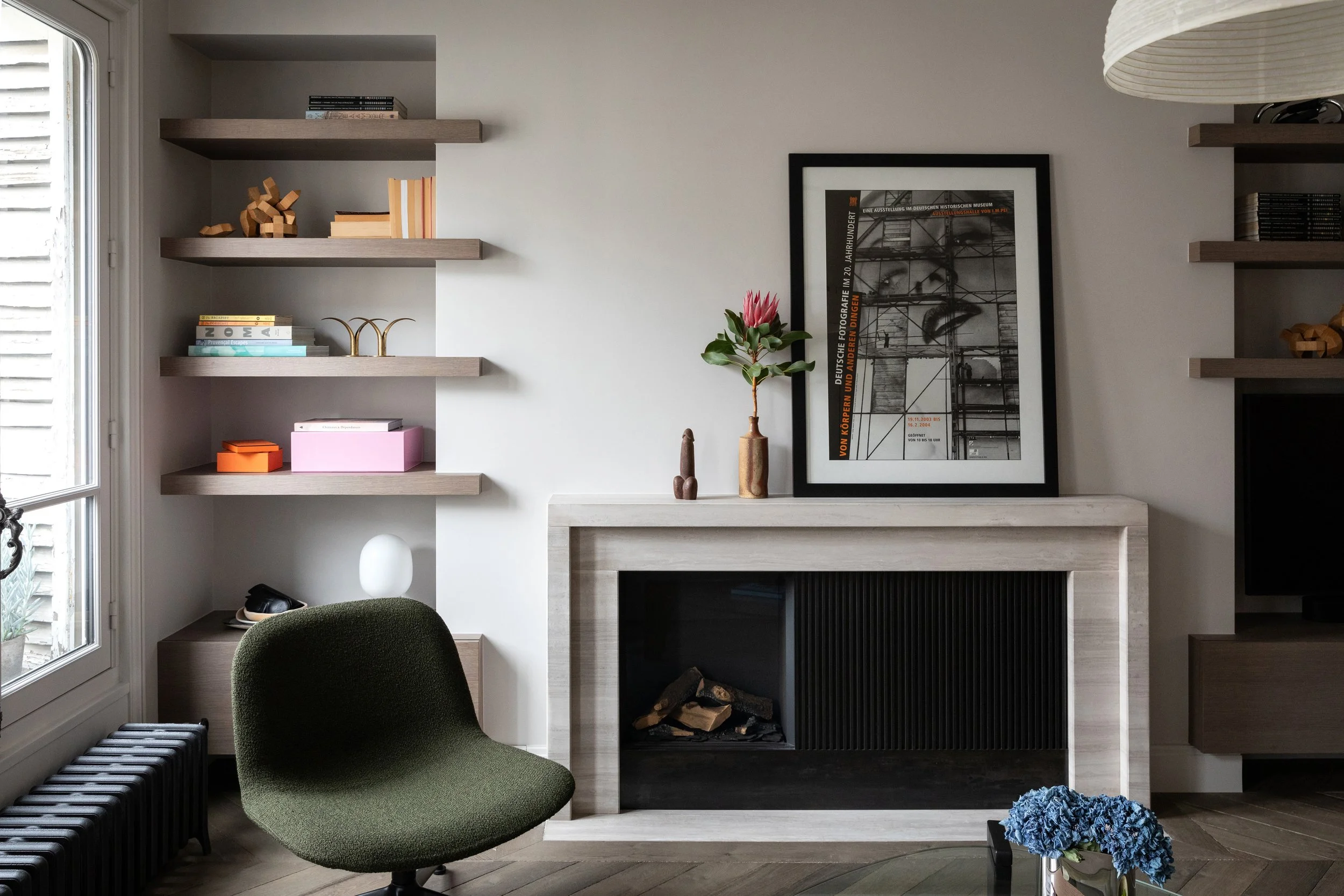 Cheminée au gaz en pierre et mobilier sur mesure dans le salon d’un appartement rénové à Paris 3