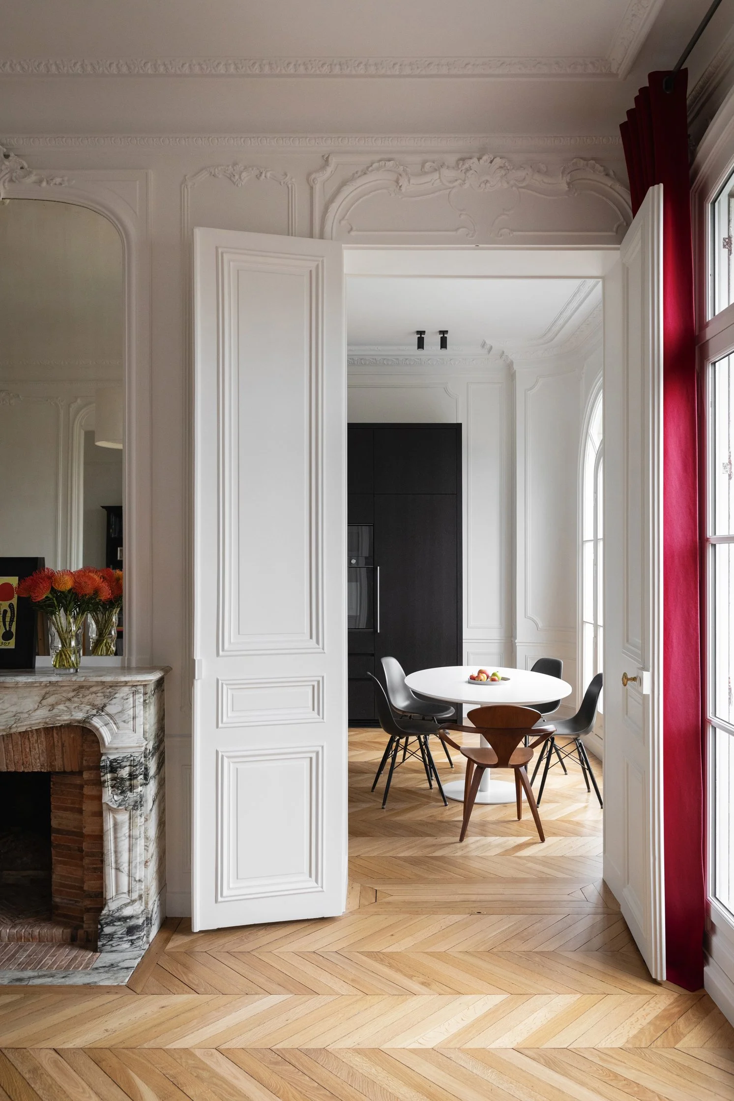 Salon d’un appartement haussmannien rénové à Paris 16, avec cheminée en marbre et parquet en point de Hongrie