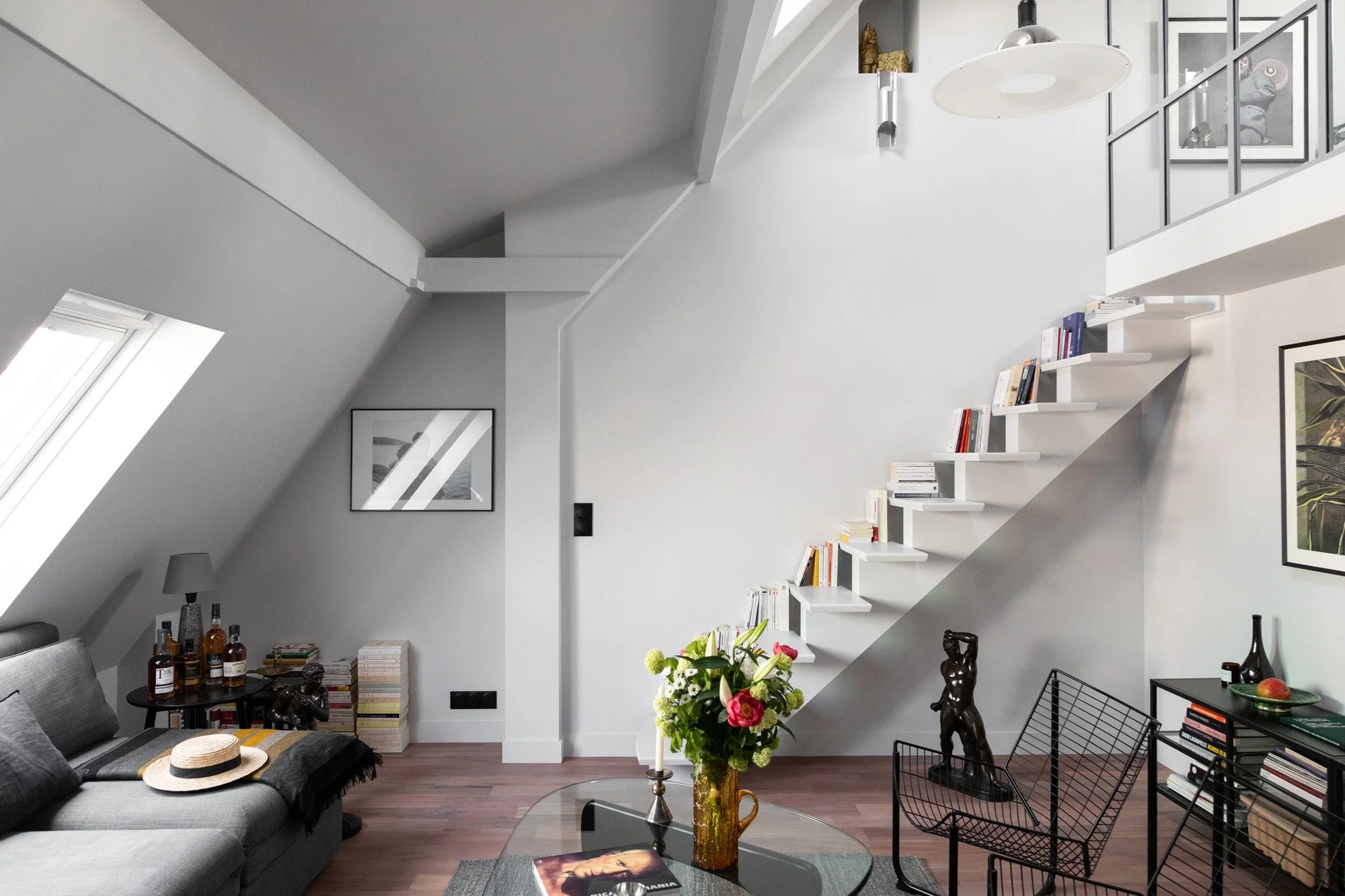 Salon d’un appartement rénové à Saint-Georges avec escalier et bibliothèque sur mesure