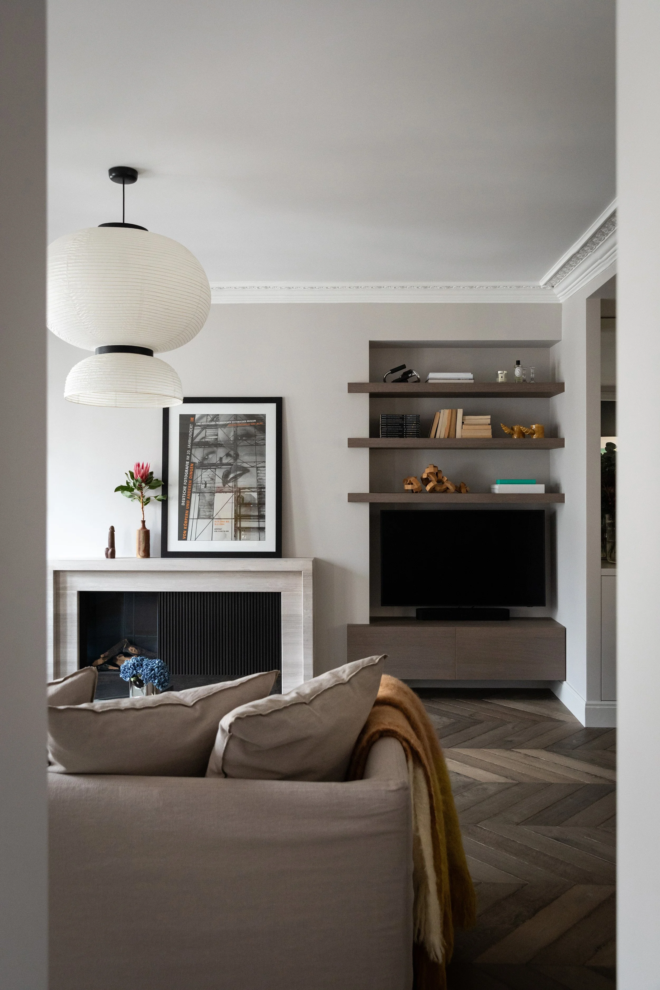 Cheminée au gaz en pierre dessinée sur mesure dans le salon d’un appartement rénové à Paris 3
