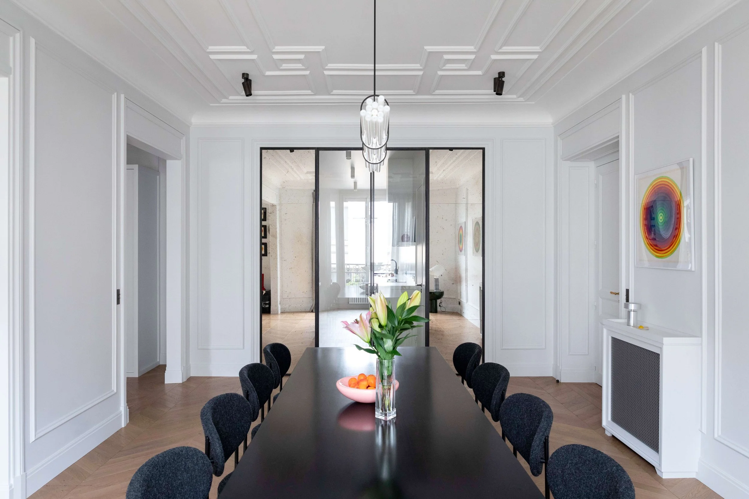 Salle à manger avec verrière en acier dans un appartement haussmannien rénové à Paris 16