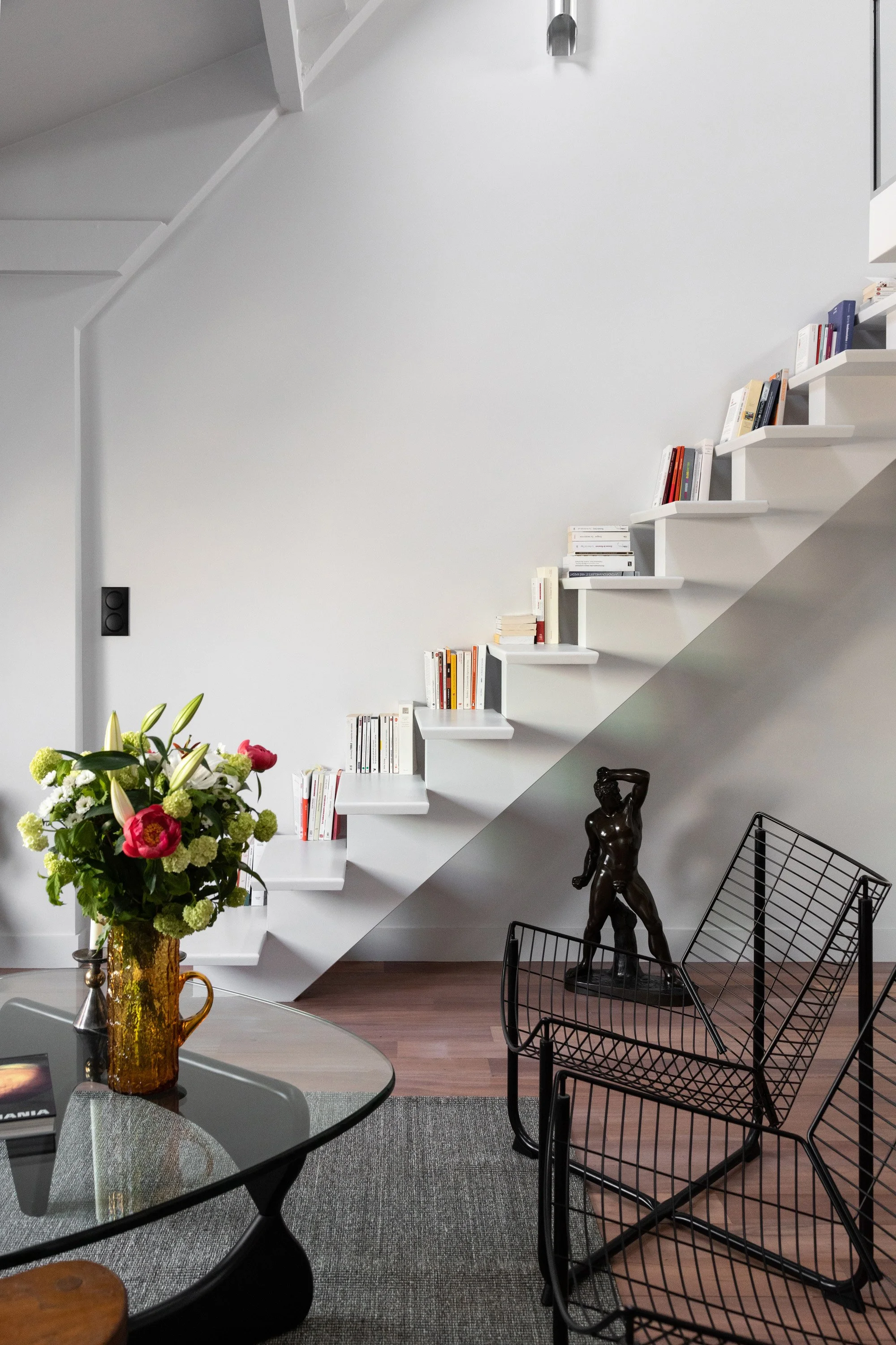 Escalier blanc avec bibliothèque intégrée dans un appartement rénové à Paris 9