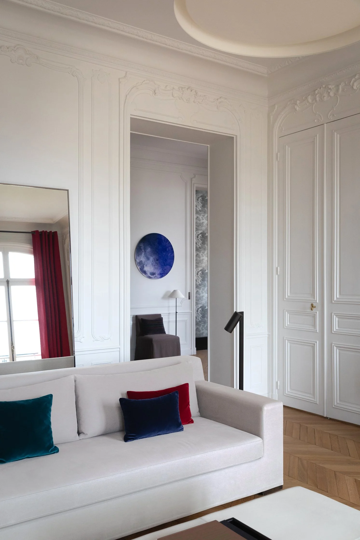 Salon contemporain dans un appartement haussmannien rénové, avec moulures, portes anciennes et mobilier sur mesure