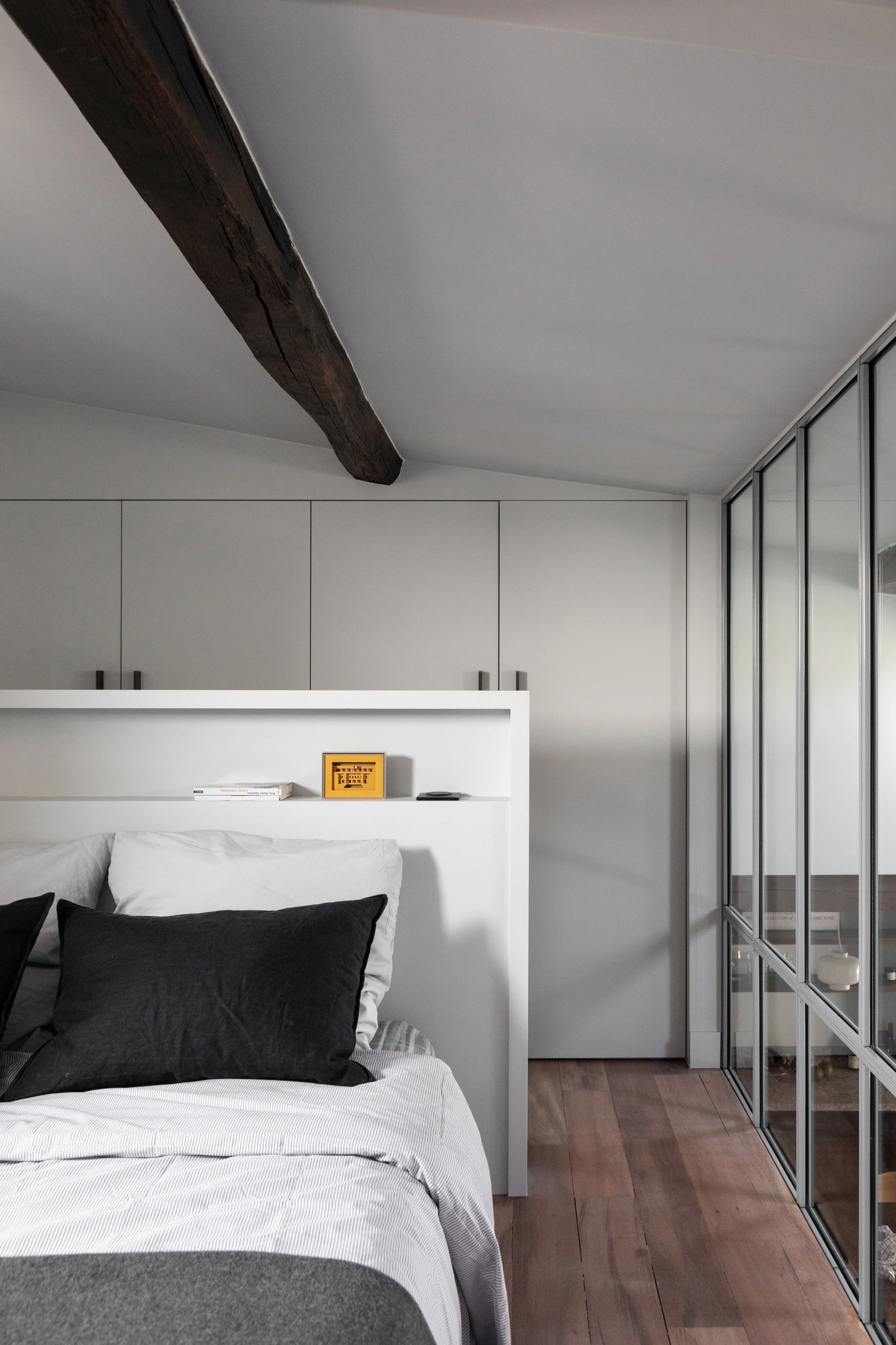 Chambre avec rangements intégrés et verrière dans un appartement rénové à Saint-Georges