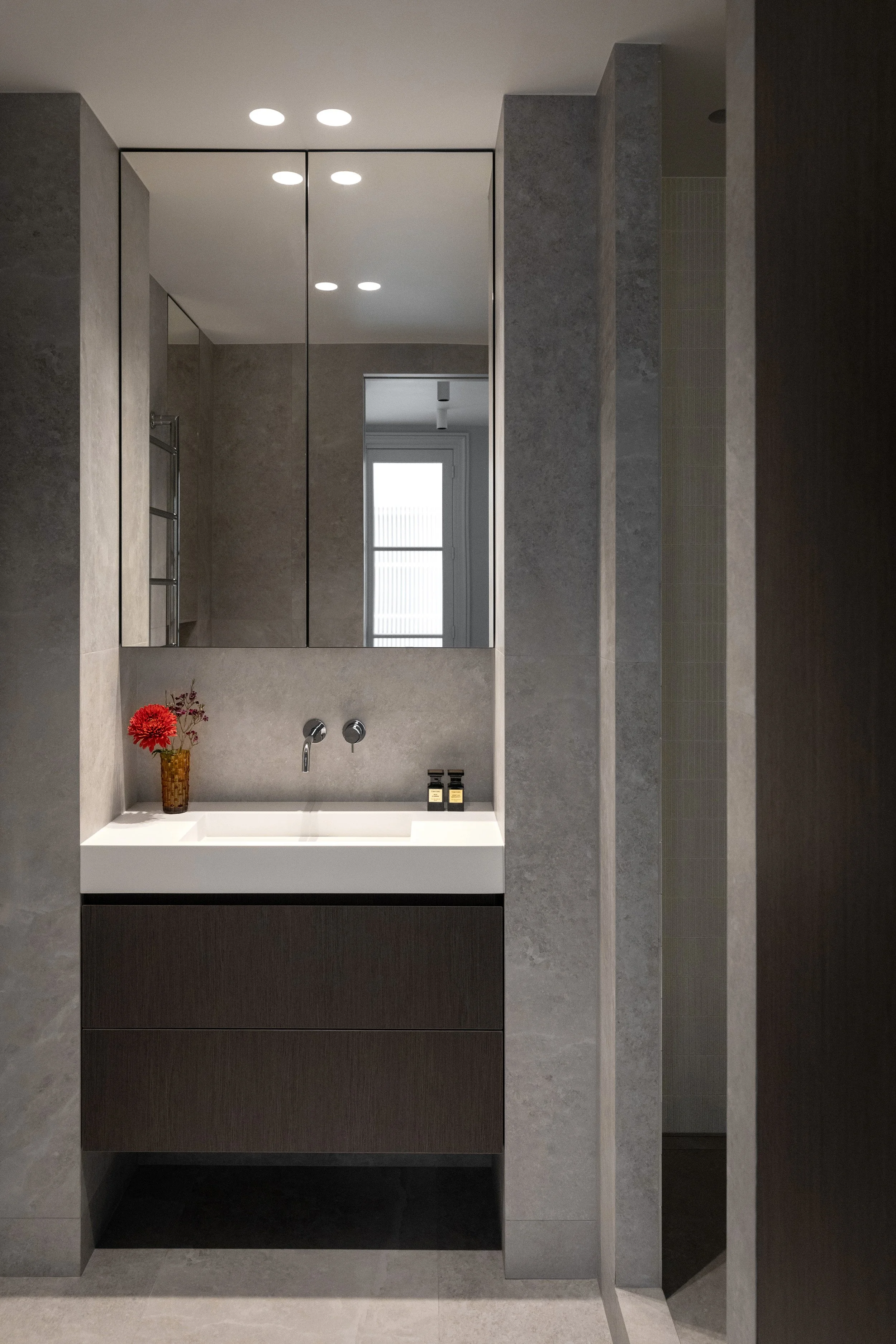 Salle d’eau contemporaine aux matériaux effet pierre dans un appartement rénové du Marais à Paris 3