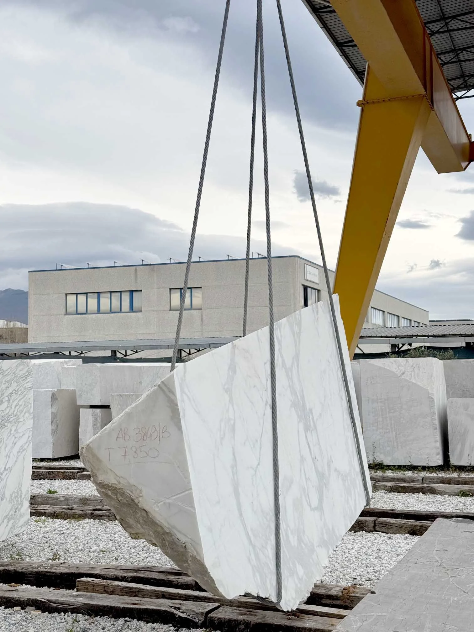 Choix et sélection d'un bloc de marbre à Carrare pour la création d'un mobilier d'accueil sur mesure pour des bureaux à Paris 4e.