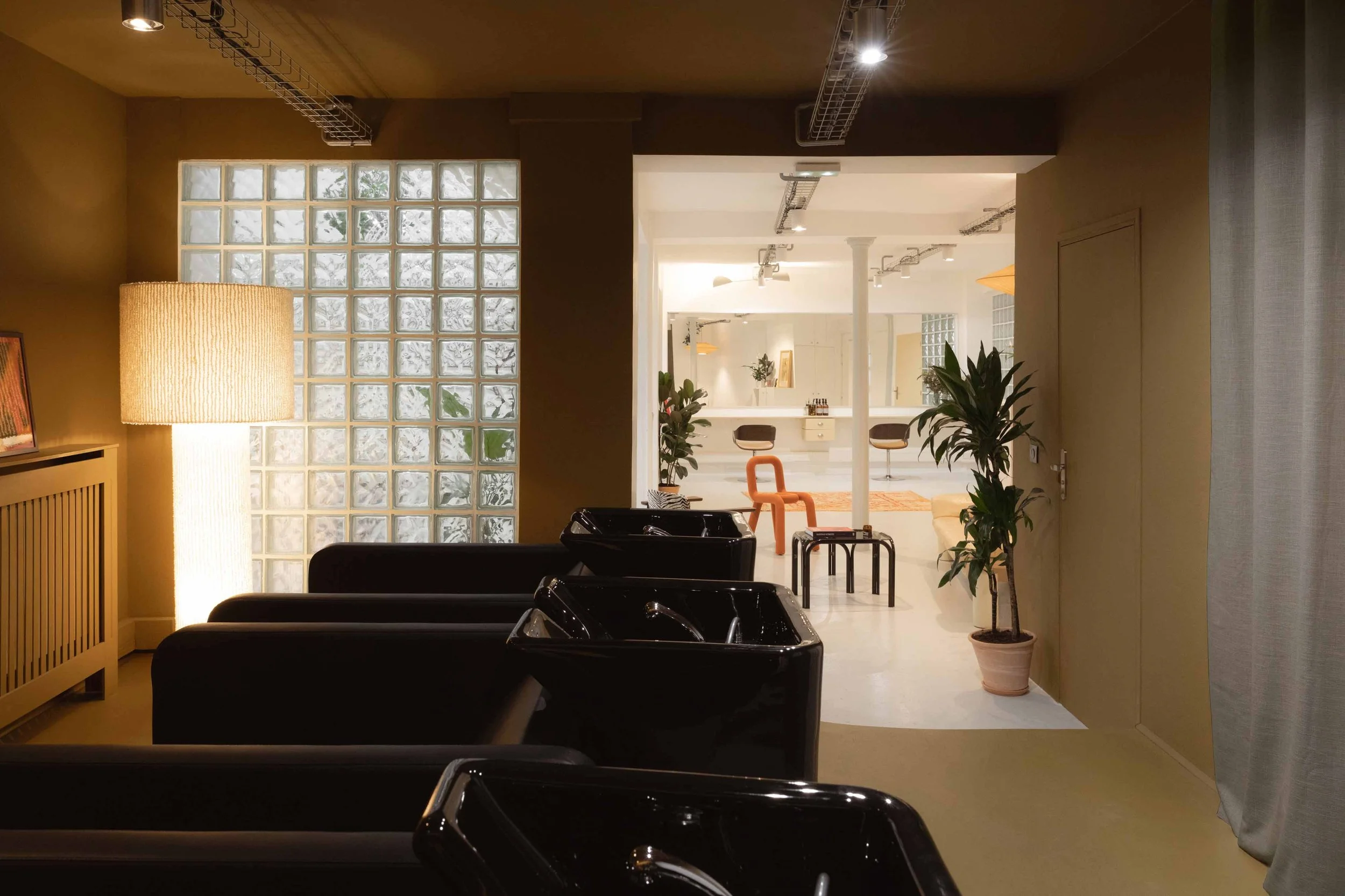 L'espace shampoing est peint en brun du sol au plafond pour lui donner de la chaleur et inviter les clients à la relaxation
