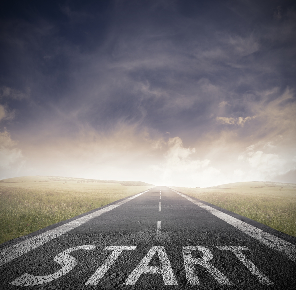 A road fading into the distance with the word “START” painted on it