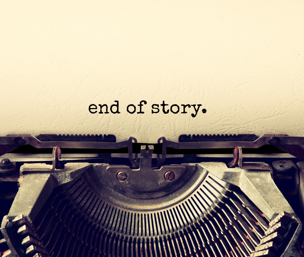 An old typewriter with the words “end of story.” typed on to the page.