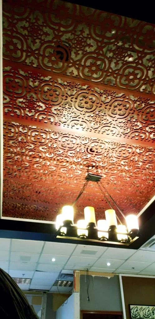 Patterned ceiling panel above hanging lights