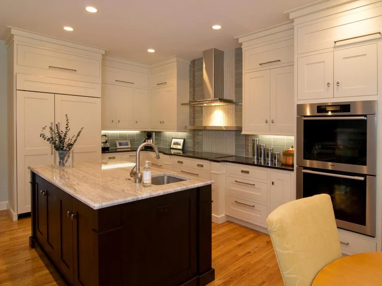 White kitchen cabinetry with a wood-finished island