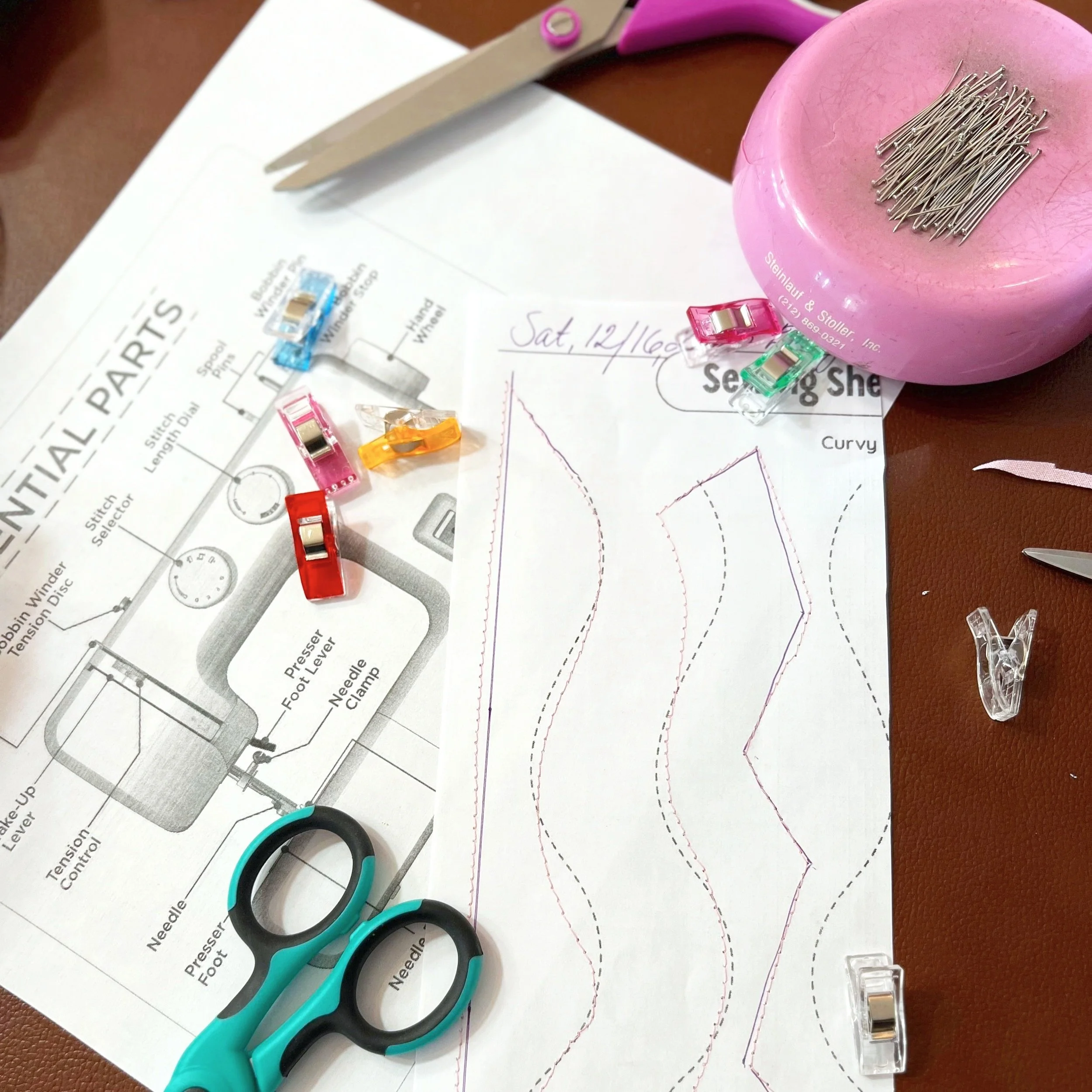 essential sewing machine parts instruction on a diagram copy paper with scissors and pins and colorful clips