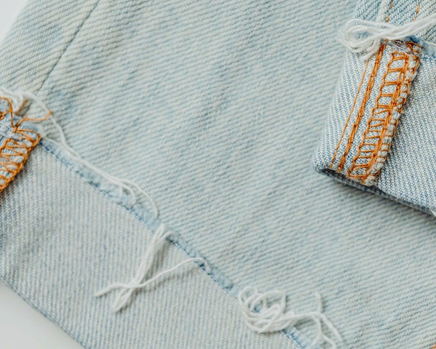 raw bottom hem edge of light blue denim pants
