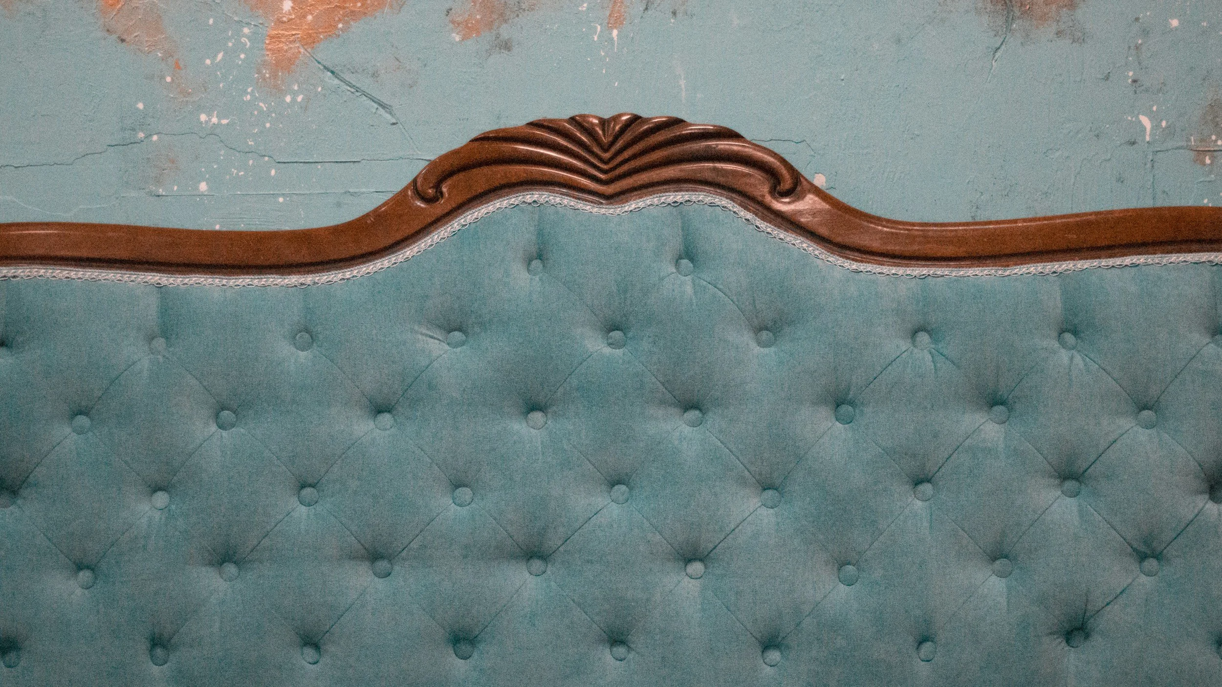 teal headboard with tufted buttons and wood border